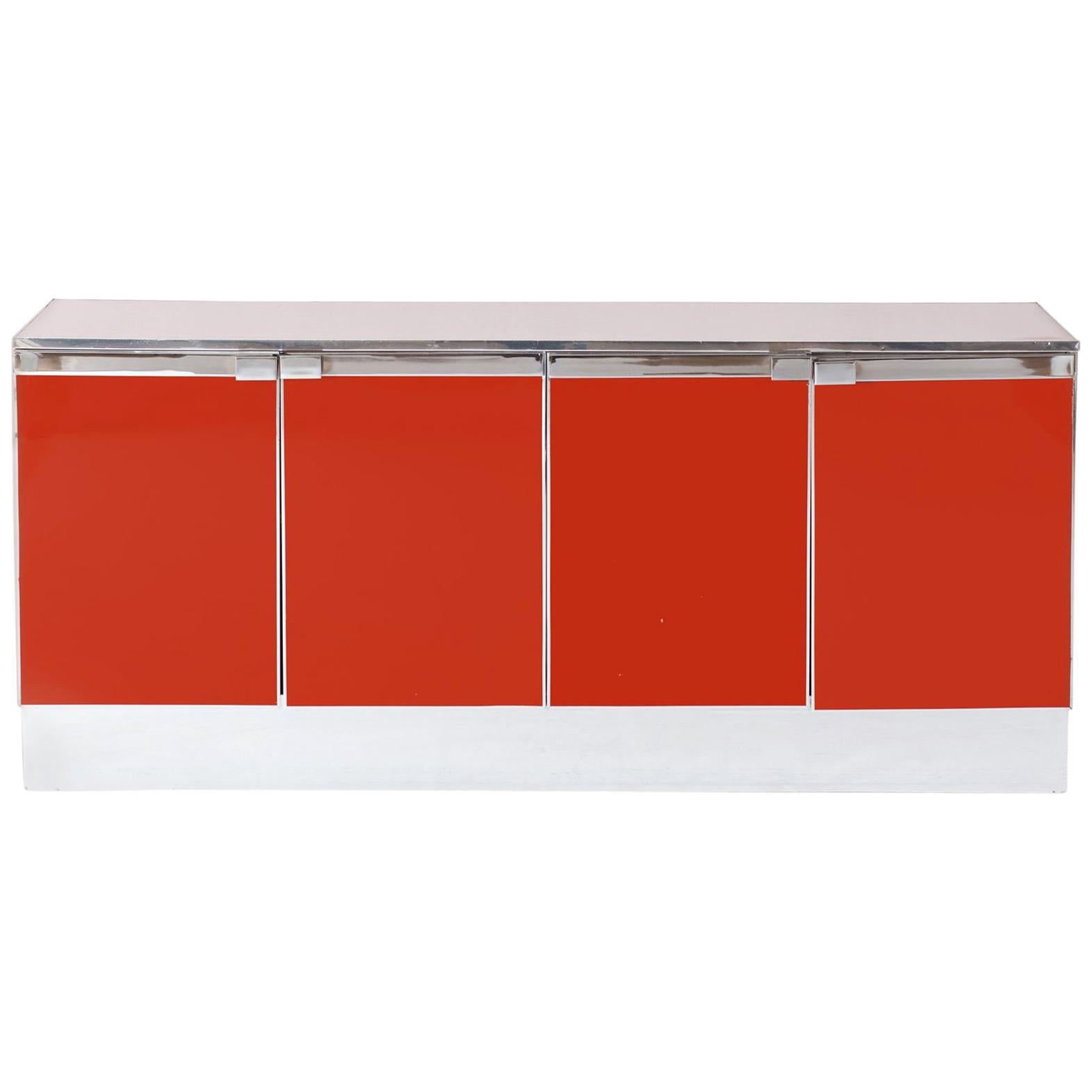 Eclectic Postmodern sideboard in red lacquer with chrome detailing all round.
The credenza has four lacquered doors which hide shelving and a drawer.
Would fit well in a metropolitan chic decor inspired by Romeo Rega, Willy Rizzo and Mario