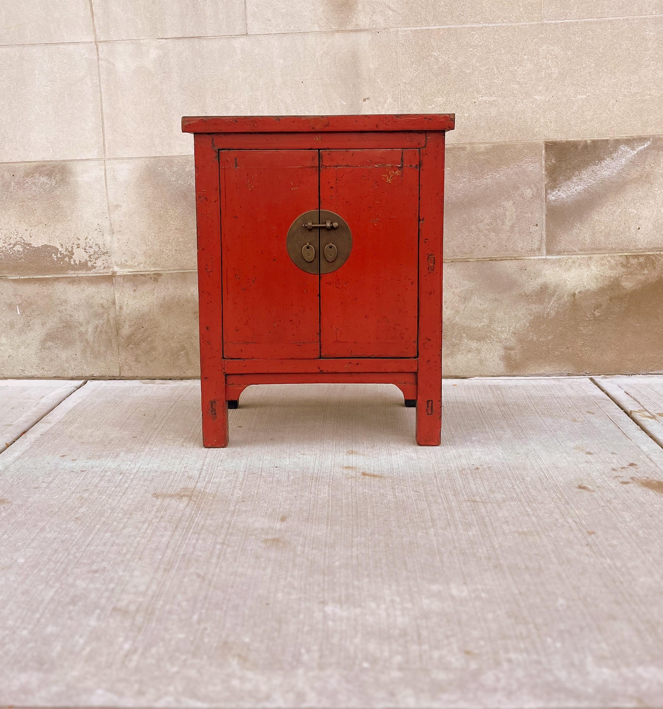 Antike rote Lacktruhe mit zwei offenen Türen und einem herausnehmbaren Regal im Inneren.