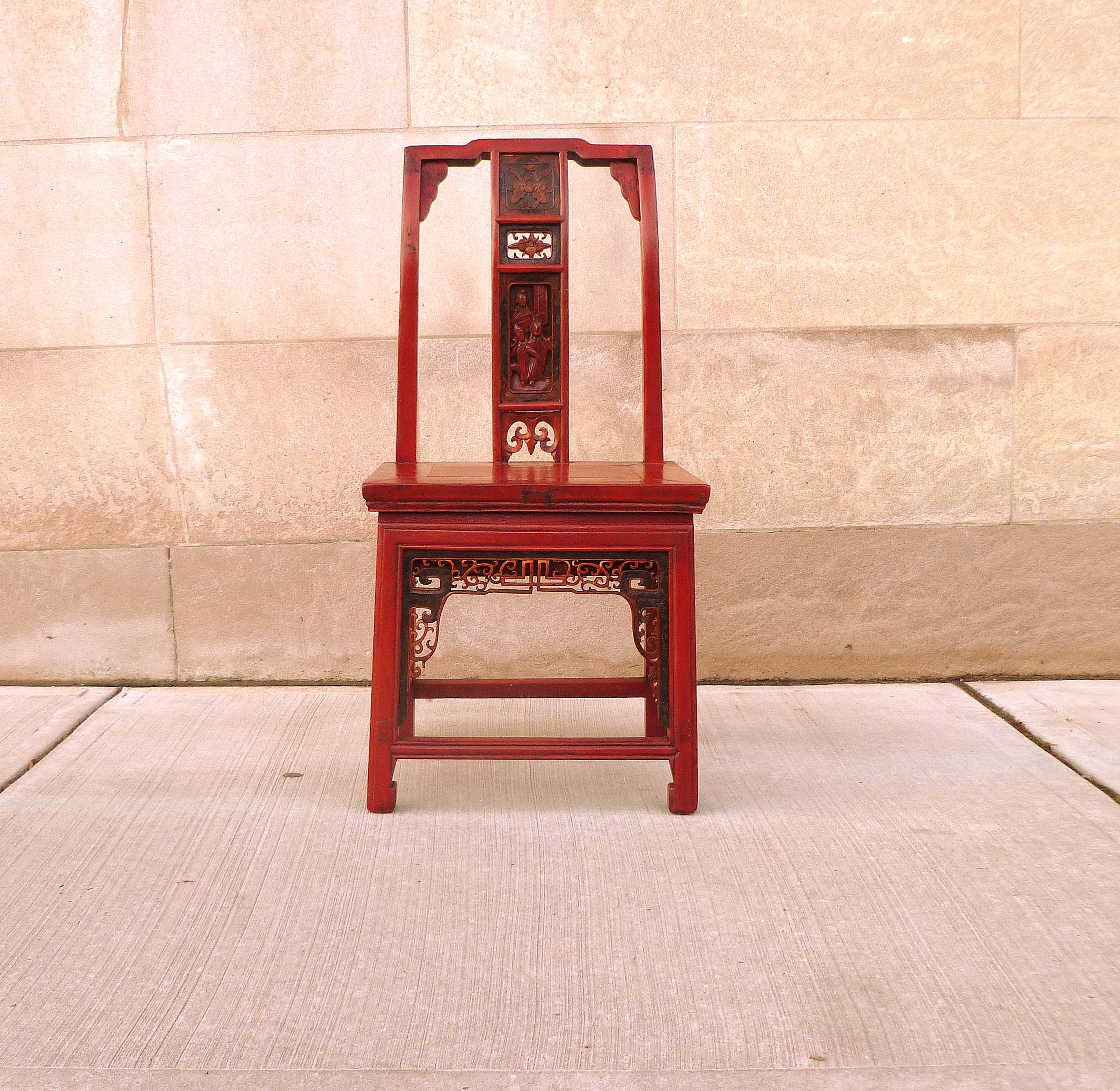 Rot lackierter Kinderstuhl mit feiner Lochschnitzerei und einer Schublade an der Seite.
