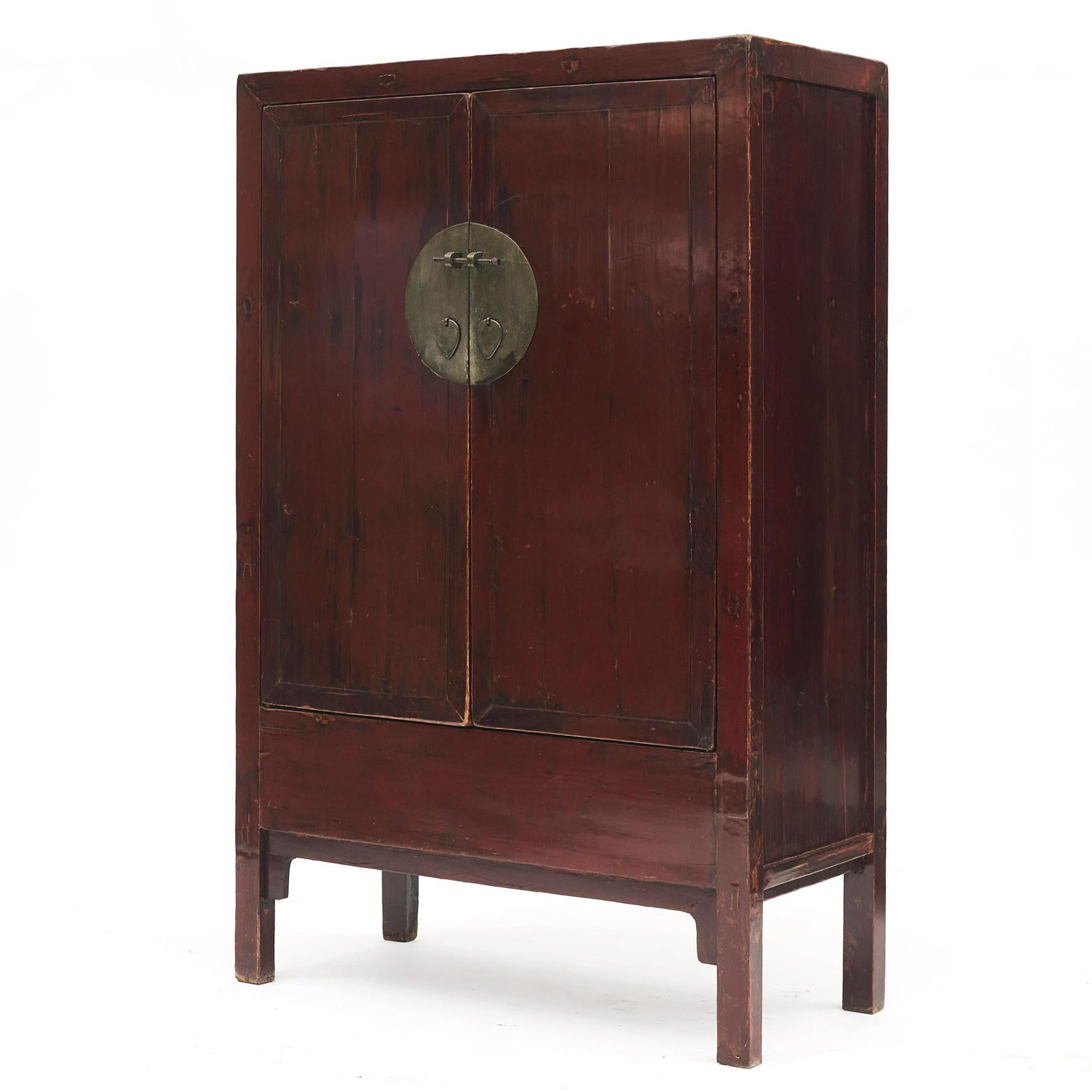Red lacquer Chinese wedding cabinet. Item features solid elm wood construction with natural patina. Two doors beautifully accented with a circular brass face plate.
From Shanxi Province, circa 1840.