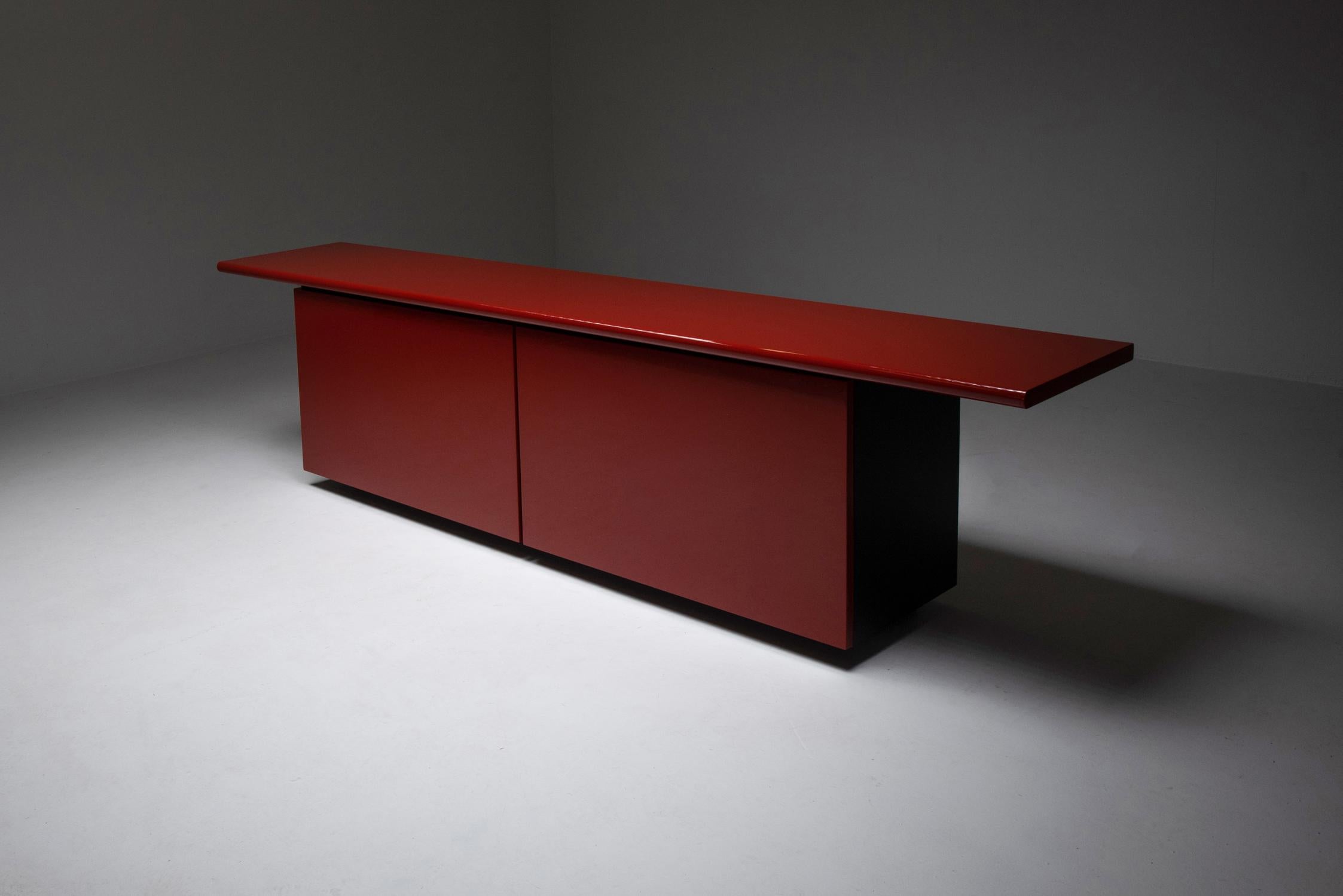 Acerbis, Giotto Stoppino, red lacquer sideboard, Italy, 1977.

Postmodern storage piece in red lacquer. The top has a floating appearance because of it's oversize width. The genius in the design here is that the doors of the credenza slide open