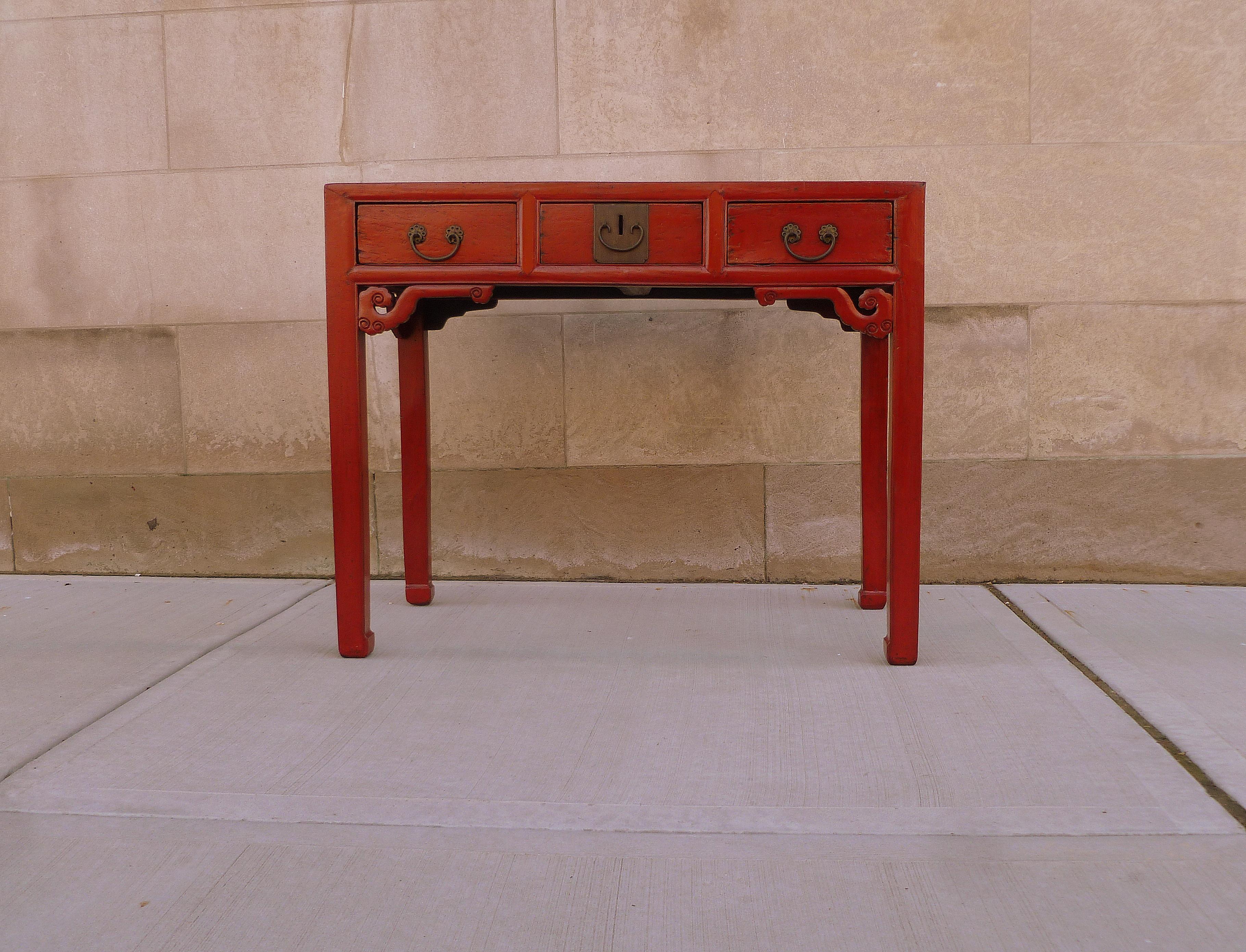 Red lacquer desk with three drawers with pierce carvings motif.