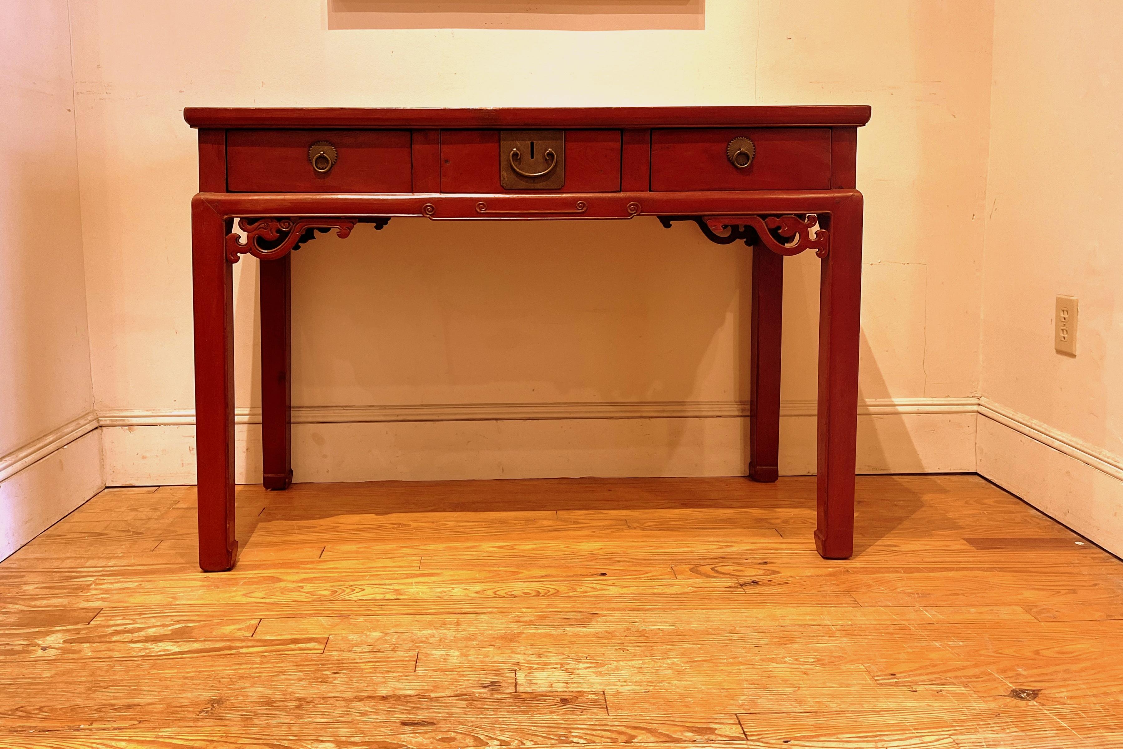 Red lacquer desk with three drawers with pierce carvings motif.