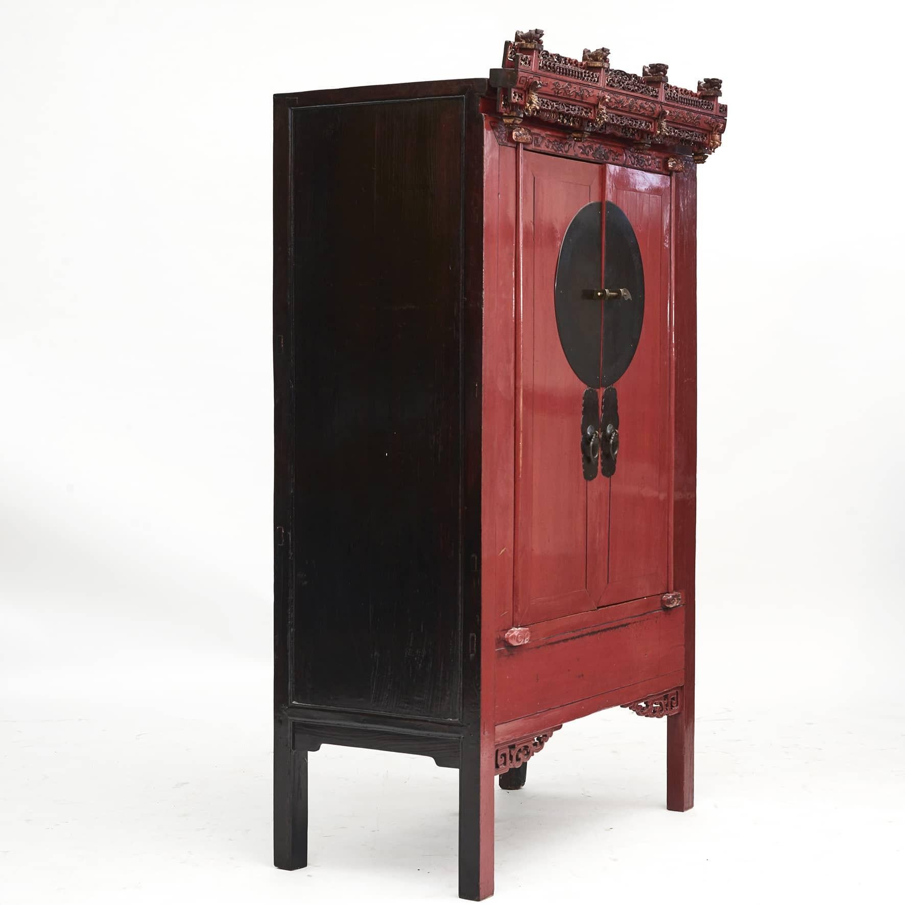 Chinese Qing dynasty red lacquer wedding armoire.
Top is richly carved with pierced foliate, crown is topped by 4 carved guardian lions, a classic decoration choise from the Fujian Province.
Very decorative cabinet in original condition from Fujian