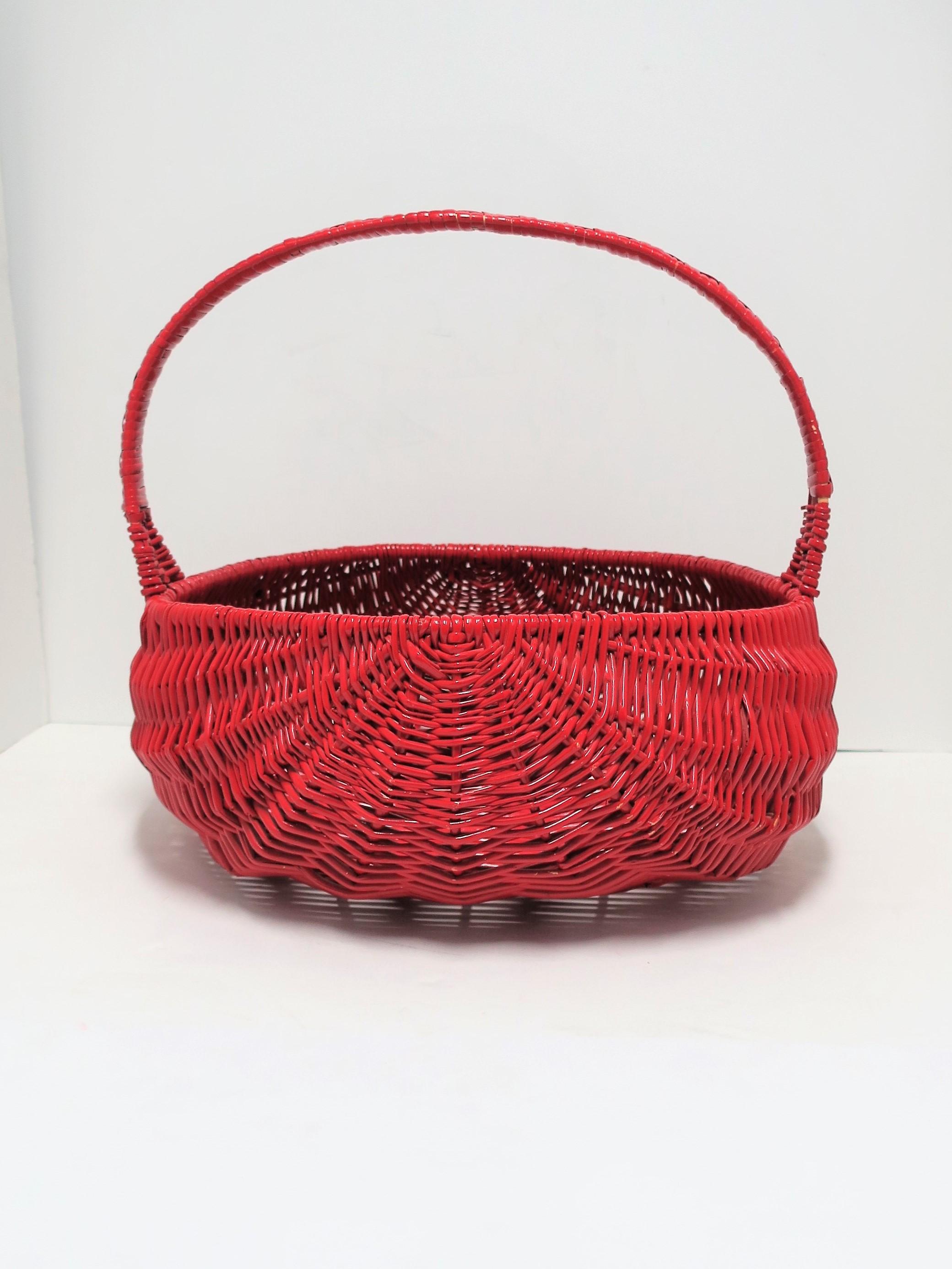 A large vintage red lacquer woven wicker basket with handle. A great woven wicker basket that can hold various items including, plants, magazines, towels, etc. Shown in image #11 with magazines. Red lacquer appears to be professionally applied.