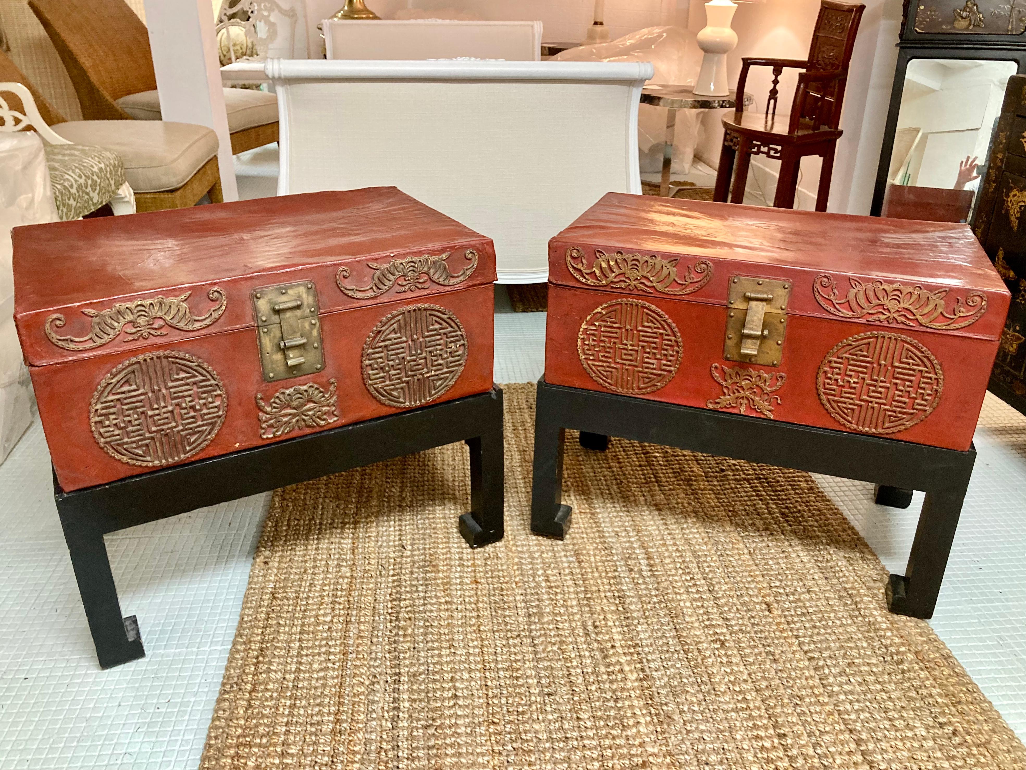 Beautiful pair of red lacquered Asian trunk side tables on black stands. Extremely decorative side tables with added bonus of great storage. Very nice artistic details on the red trunks. The bases are custom fitted to each trunk \. Add some Asian