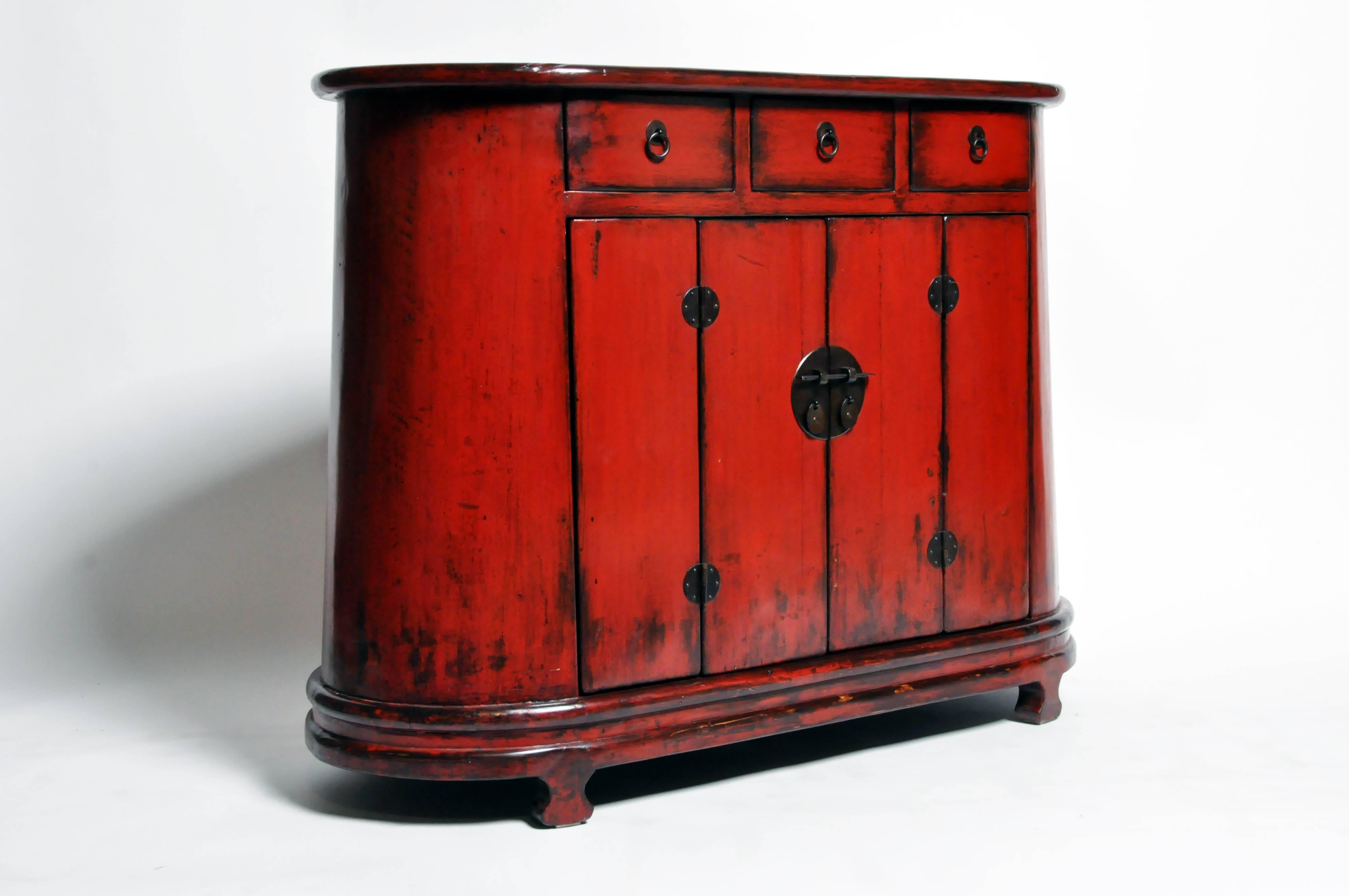 This cabinet is from Gamsu, China and was made from reclaimed elm wood and red lacquer. The piece features mortise and tenon joinery, three drawers, two bi-fold doors, and a shelf for additional storage. You can also customize a new one and make it