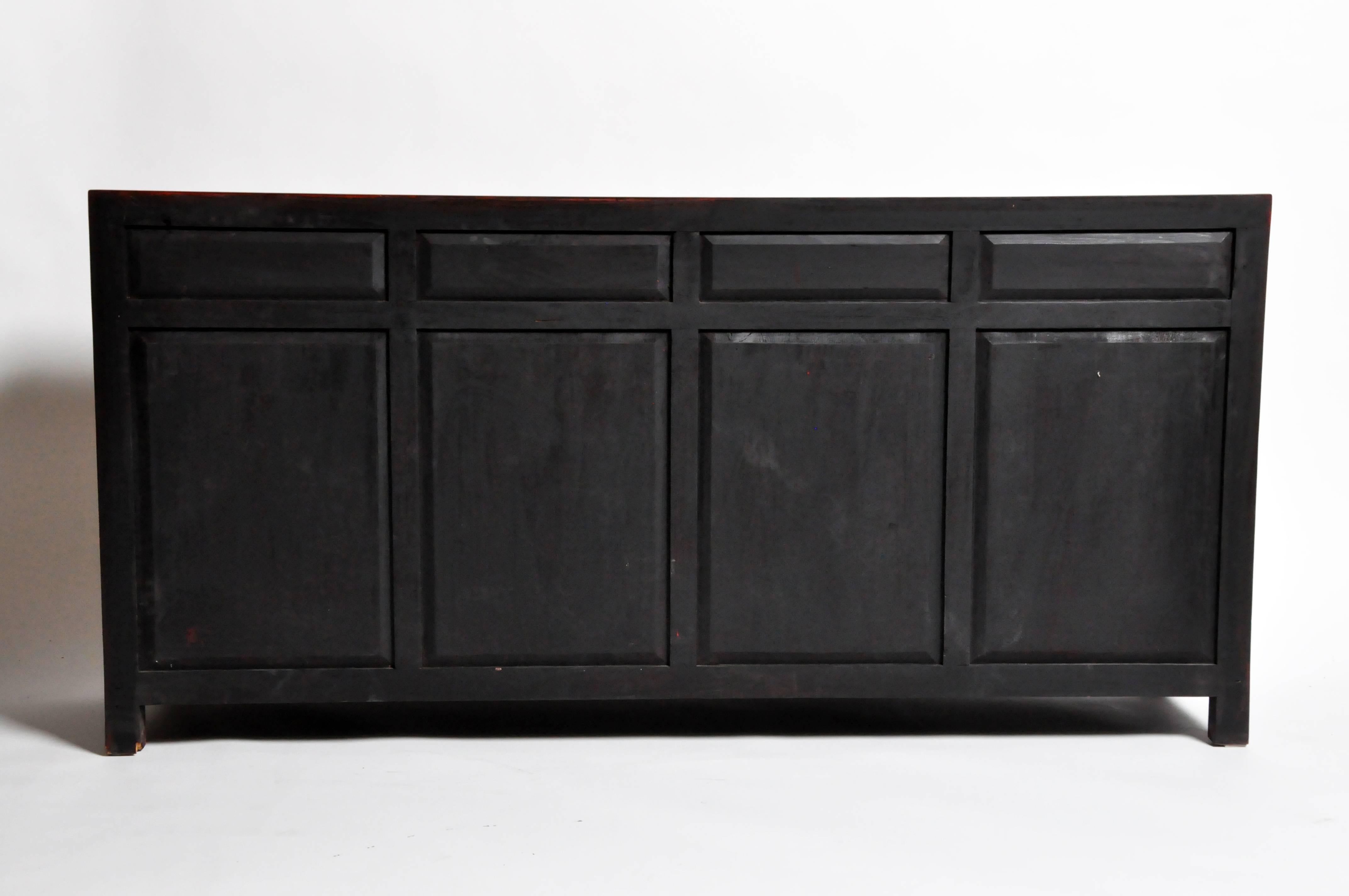This bold sideboard is the perfect focal point for any room. Originally from Hebei, China the piece was made from reclaimed elm wood and red lacquer. The piece features mortise and tenon joinery, four drawers and shelves below for ample storage. You
