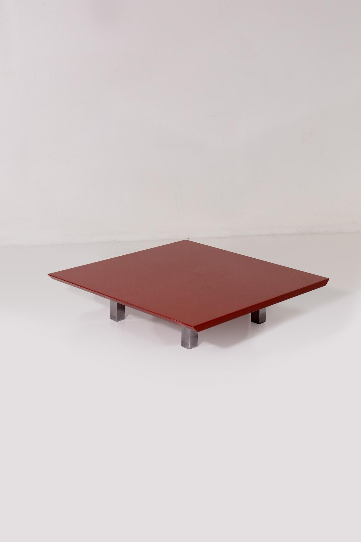 This elegant low table, designed by Vittorio Introini in the 1970s for the renowned production house Saporiti, is a perfect example of minimalist and sophisticated design. The top, in glossy red lacquered wood, immediately catches the eye with its