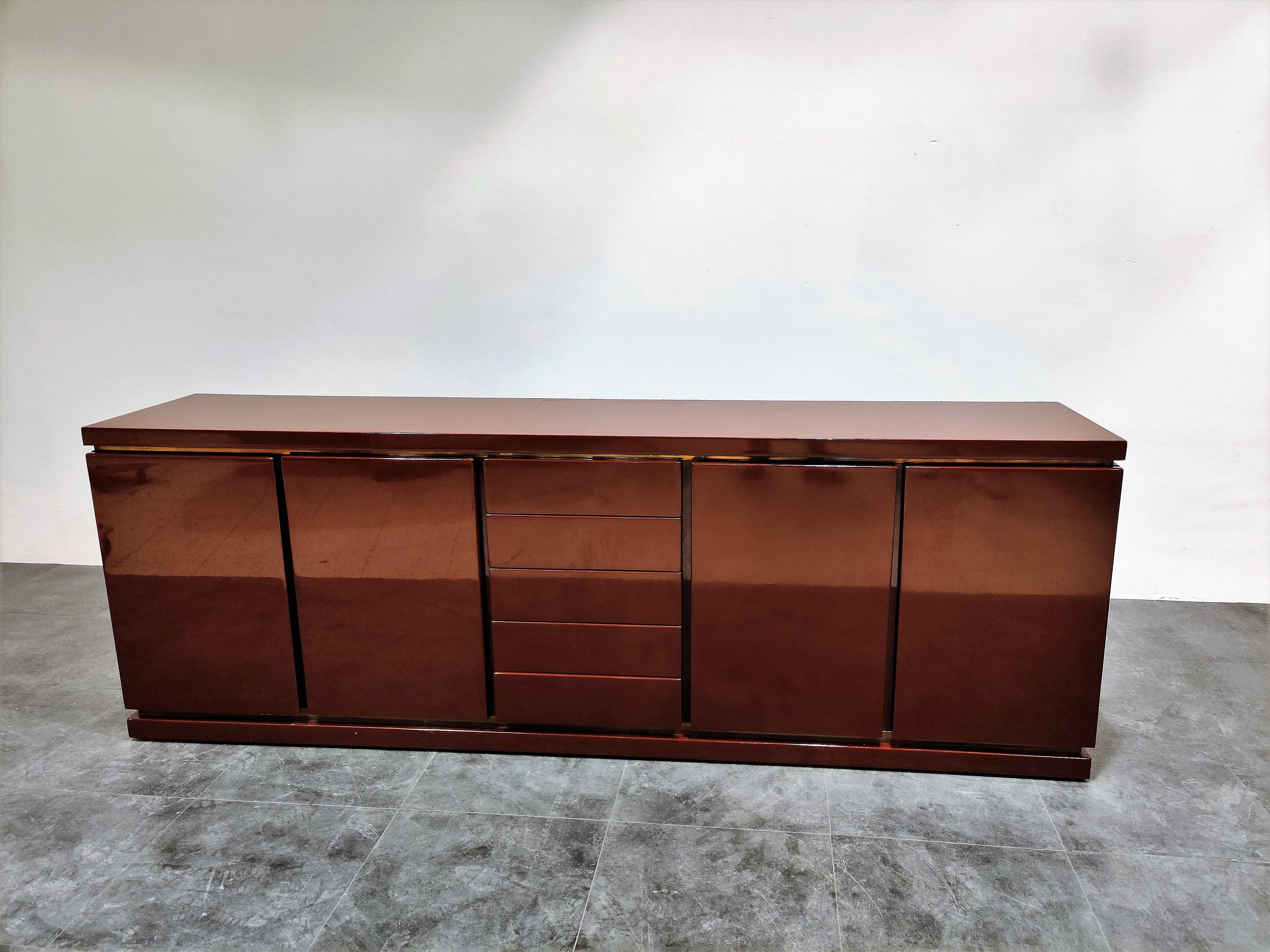 Very rare red lacquered credenza by Jean Charles. 

It features 4 doors and 5 central drawers.

The credenza is made of high quality materials and has a great 1970s-1980s glamourous look.

It screams 'luxury' and blends in well with other