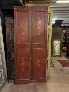 Red lacquered double-wing door, with golden decorations on the panels, Italy