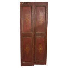 Red lacquered double-wing door, with golden decorations on the panels, Italy