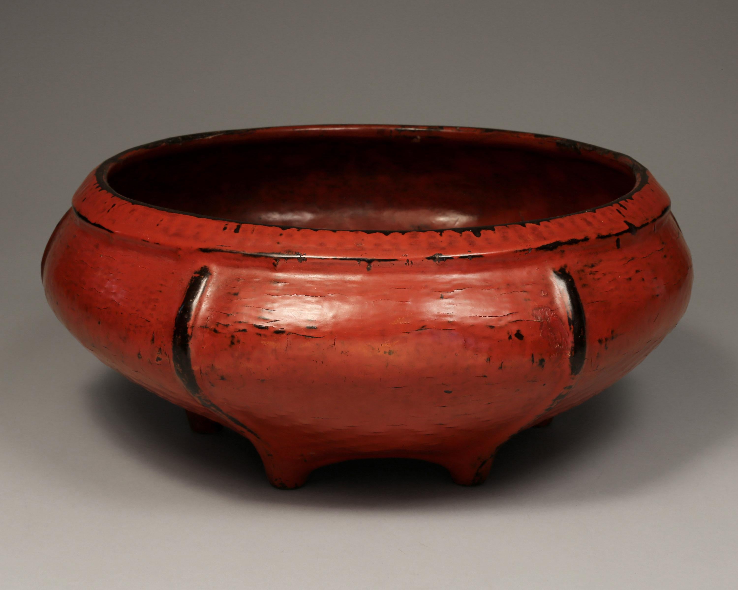 Burmese woven bamboo and red lacquered offering bowl, early 20th century

This lovely offering bowl features six distinctive black ribs and six feet on black bottom. Note artist's signature. Woven bamboo is lacquered in layers - first black, then