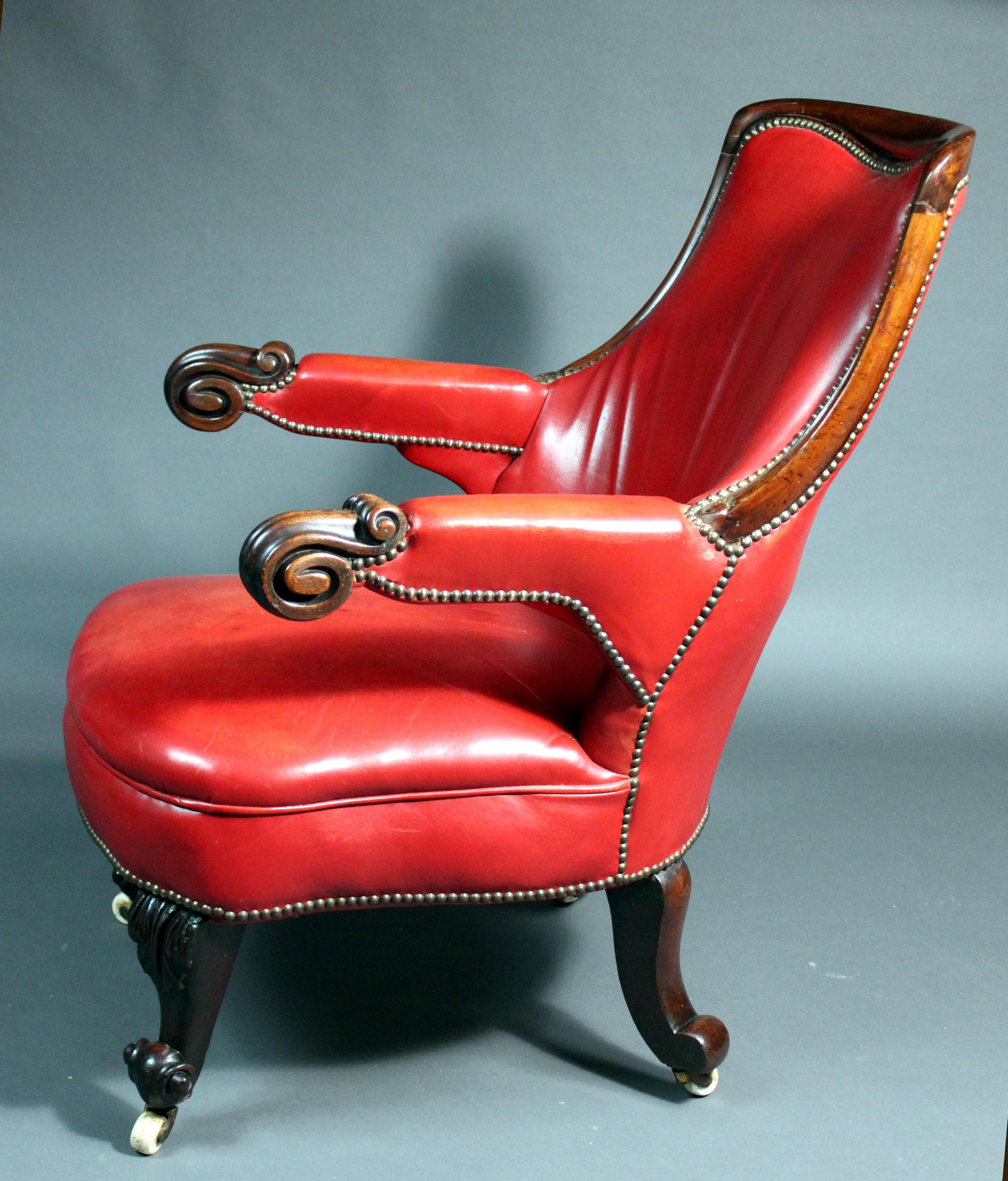 A Victorian red leather armchair of a good large size with well-carved mahogany arms and legs.