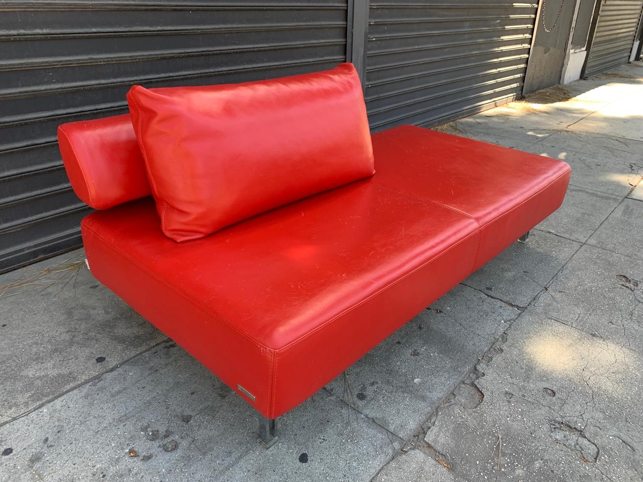 Vintage leather chaise designed and manufactured in Italy by Nicoletti Italia. The sofa is upholstered in red leather with chrome legs and Lucite caps on the feet. The sofa has been used and it has scratches to leather as shown in the photos. The