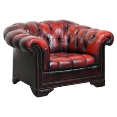 Red leather Chesterfield button seat armchair with elegant round shapes