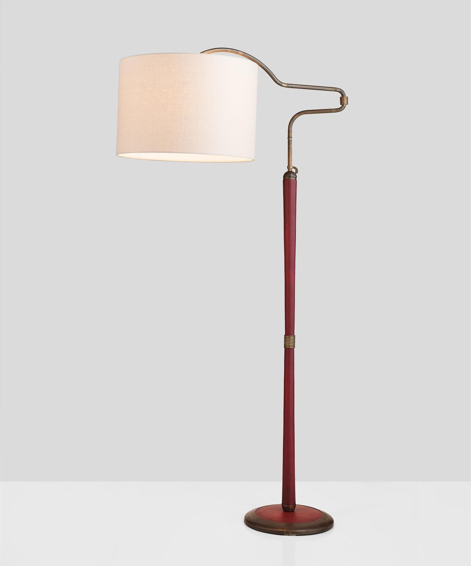 Red leather floor lamp, Italy, circa 1950.

Leather-wrapped stand includes brass detailing throughout and multiple points of adjustment. New linen shade.

Measures: 36” W x 18.5” D x 66 - 78” H.