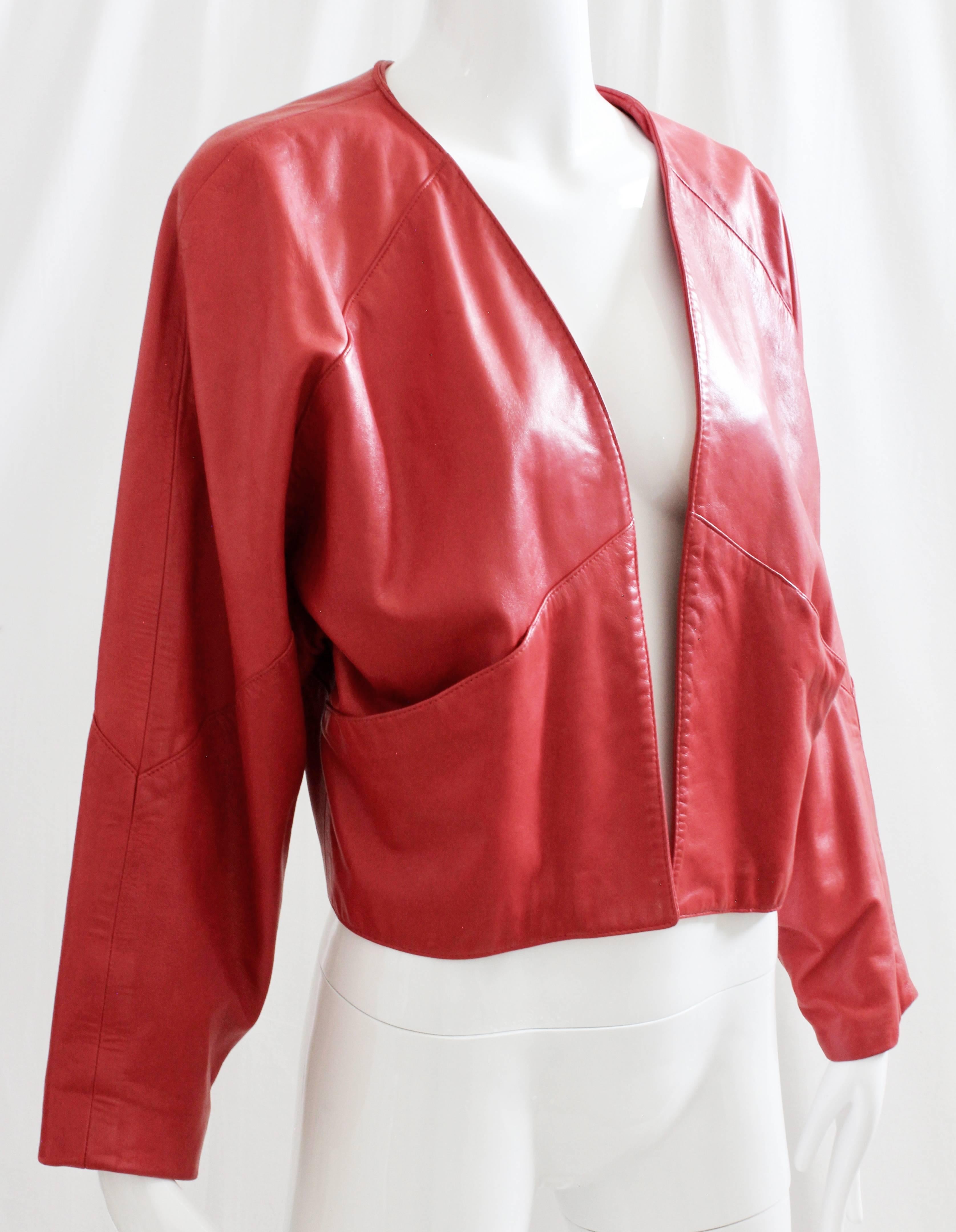 Here's a brilliant red leather jacket, likely made in the 80s.  Very retro with its Dolman sleeves, it's open style without fasteners and is perfect for layering.  No size tag, but we're estimating this as a modern M, based on these measurements: