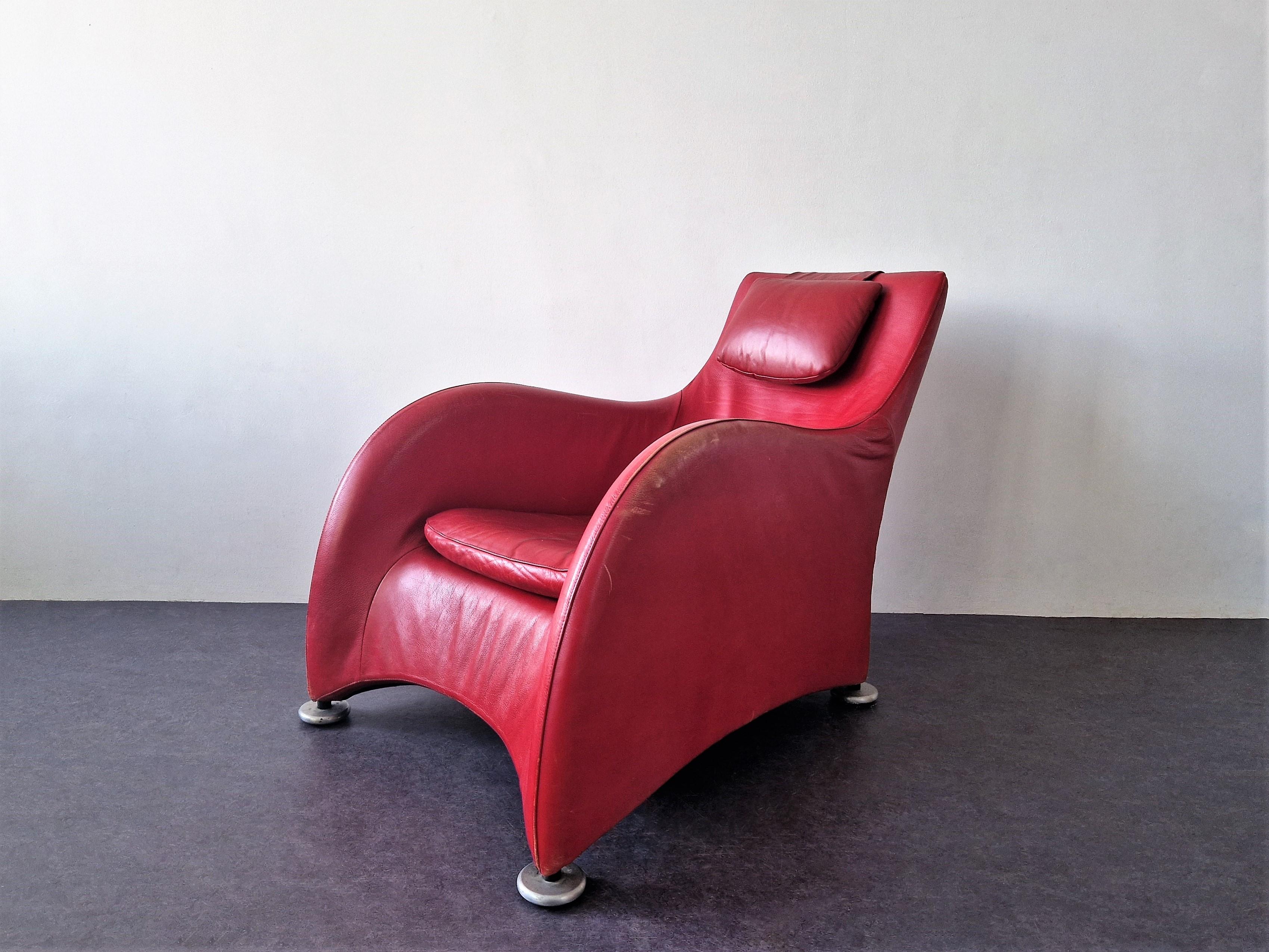 This 'Loge' lounge chair was designed by Gerard van den Berg for Montis in 1989. A beautiful chair with red leather upholstery and metal legs and this piece comes with an additional head/back cushion, that is hung over the back rest. The chair is a