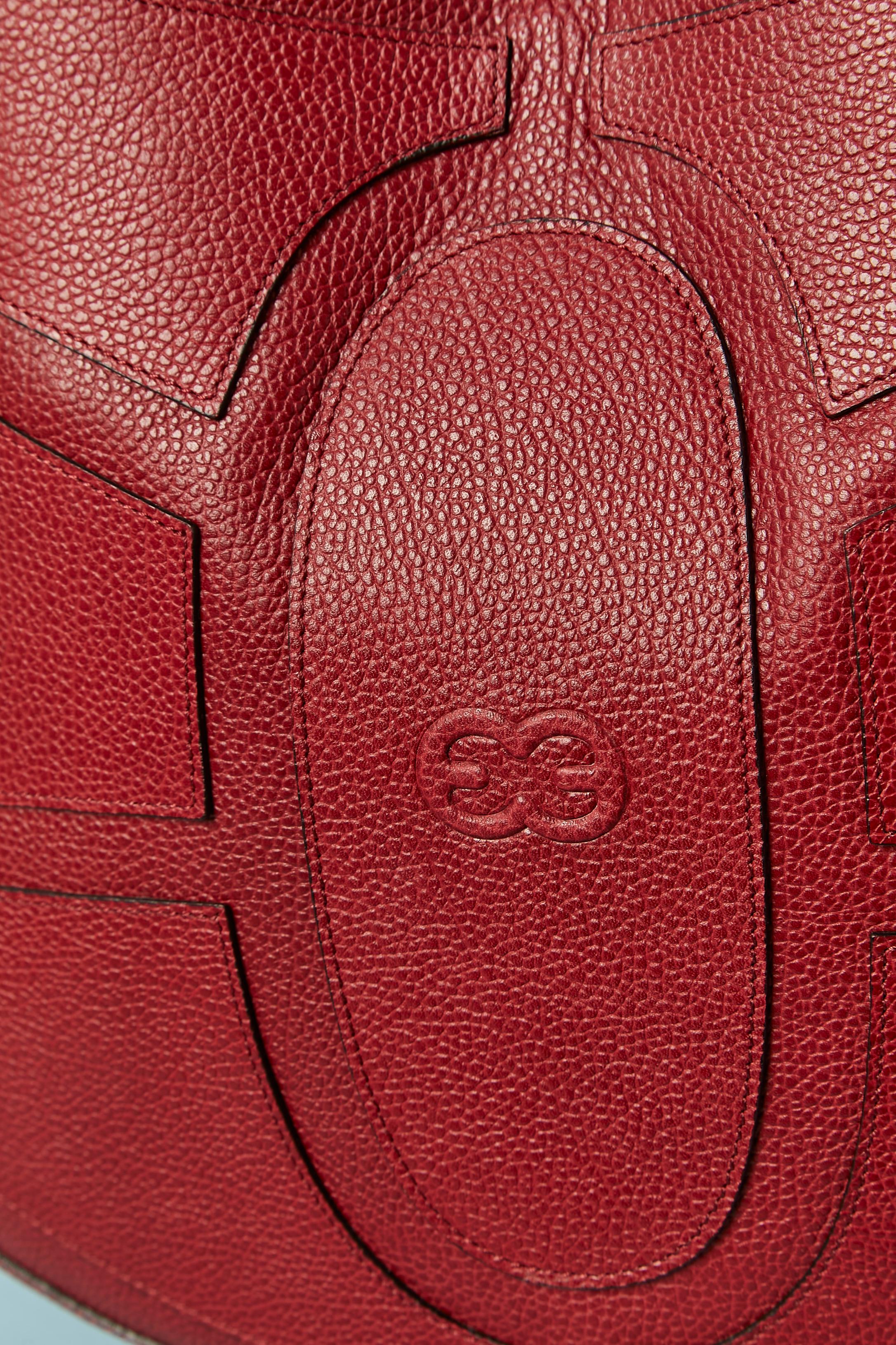 Bolso de asa superior de piel roja. Cierre a presión en la parte superior interior. Forro de nailon con la marca. 
3 bolsillos en el interior ( 1 con cierre de cremallera, 2 sin) Bolsa guardapolvo incluida. 
TAMAÑO: 38cm ( longitud) 30cm ( altura)
