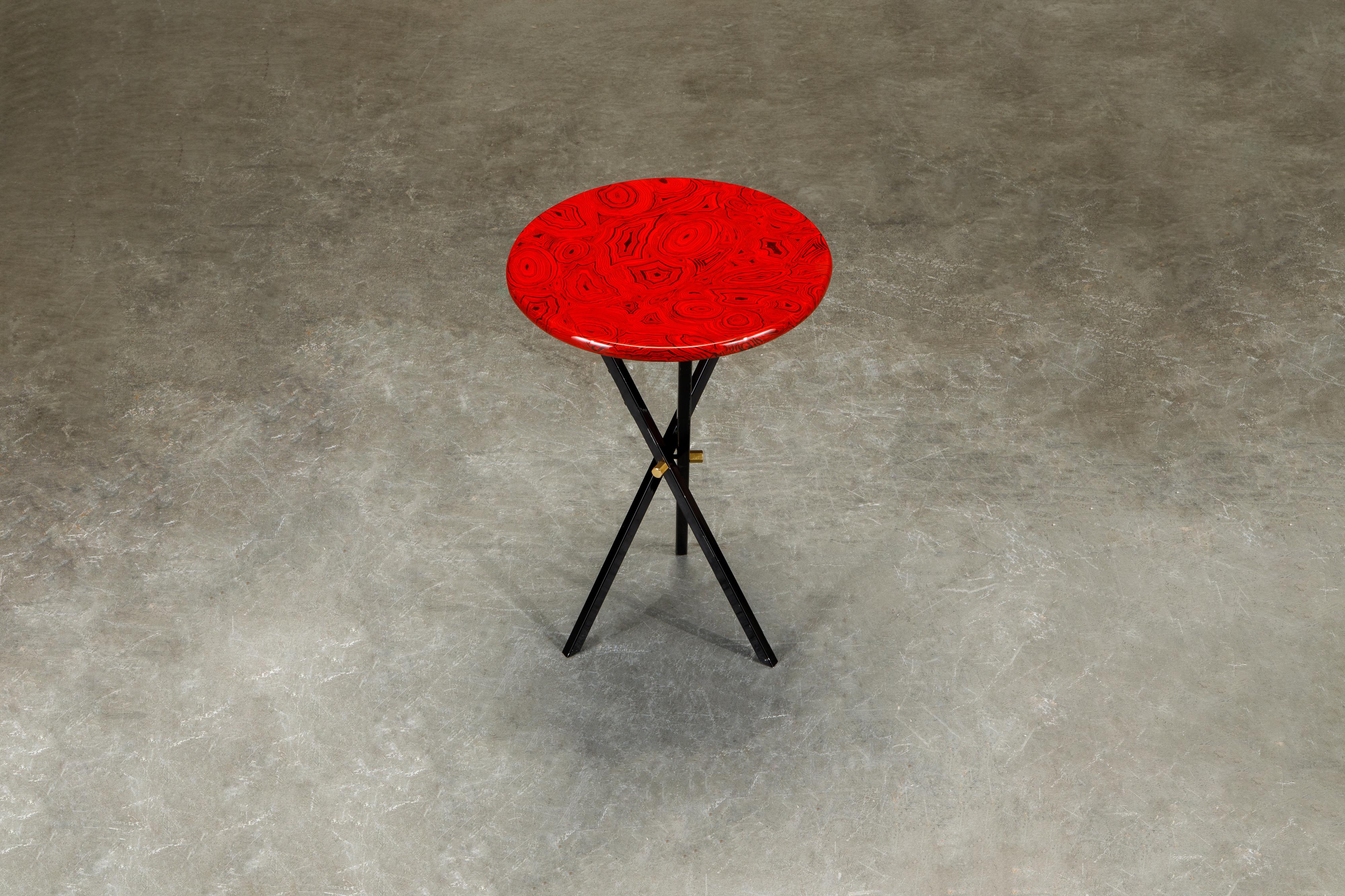 This gorgeous collectors item is a 'Red Malachite' side table by Piero Fornasetti, signed underneath with its original label. The side table is made with lacquered wood that has a malachite motif in red and is affixed on top of a black painted brass