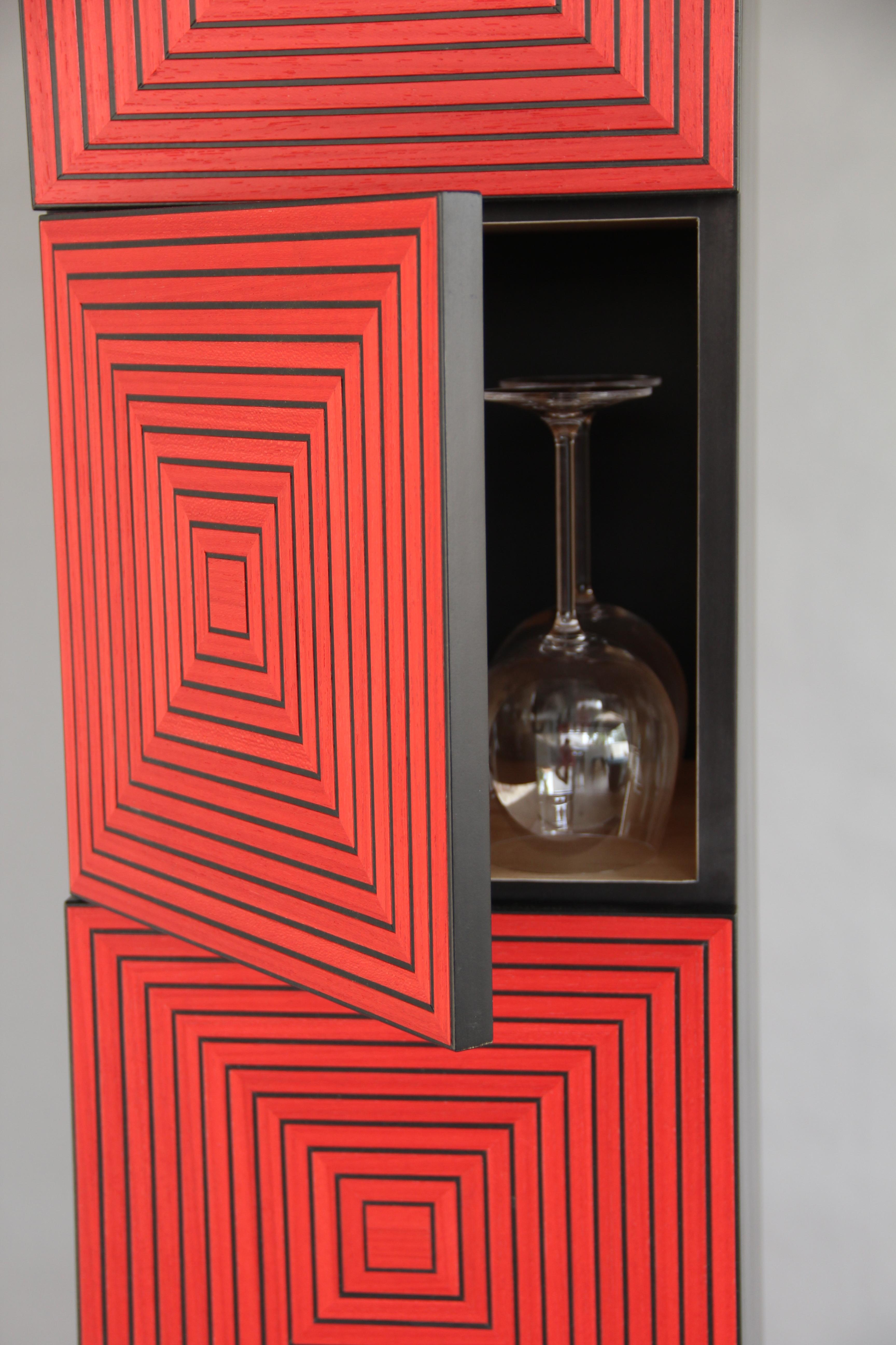 The Maze Tower is a five-door vertical cabinet with an intricate pattern of veneer strips that are individually hand cut and applied by the artist. Each door front is created from 44 pieces of veneer that produce an optical effect due to light