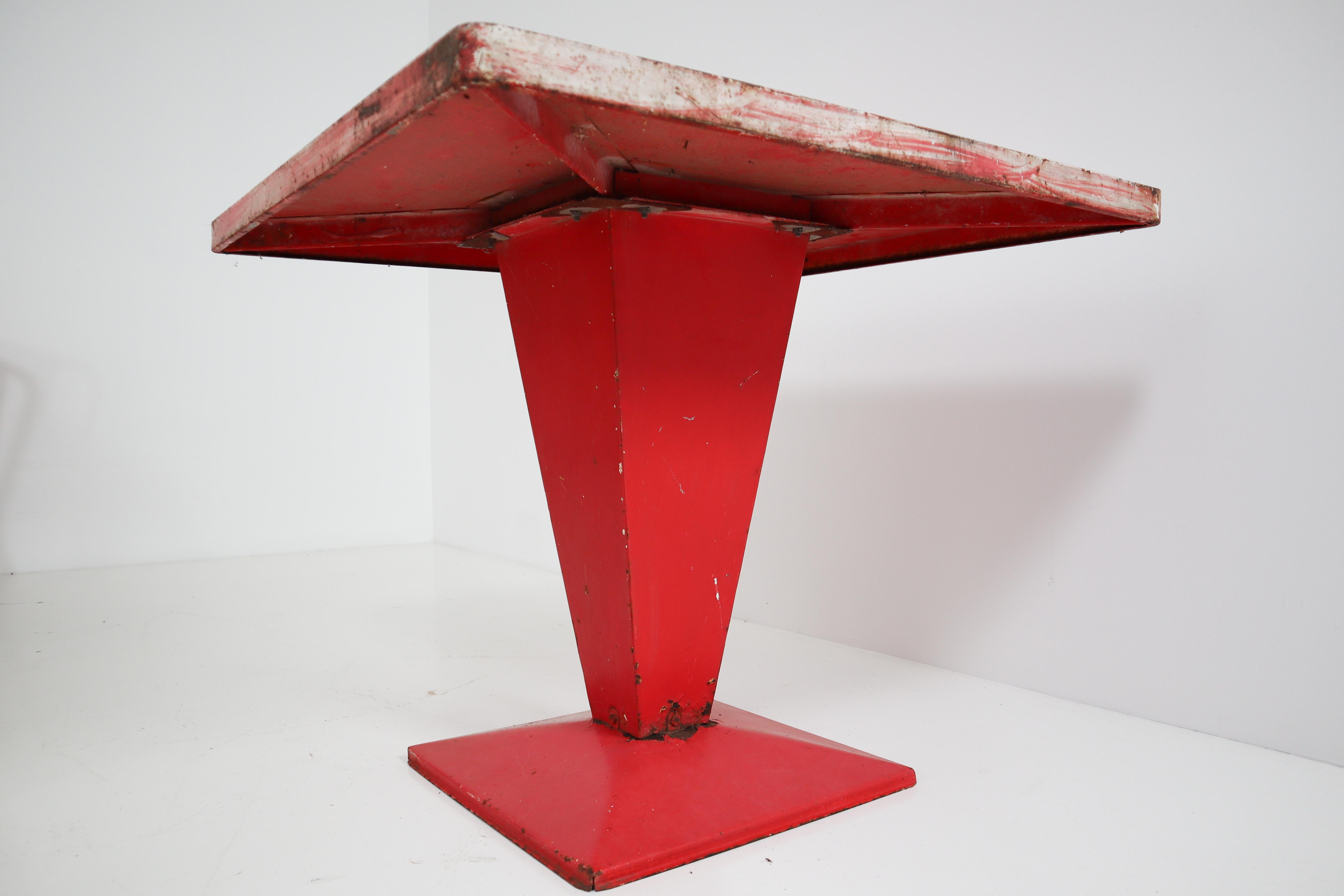 This red/white Tolix table with original patina is extremely rare. The squared base is in fact a typical feature that always characterizes the squared structure of the bistro table known as 'Cube' table. The contrast created in this piece of