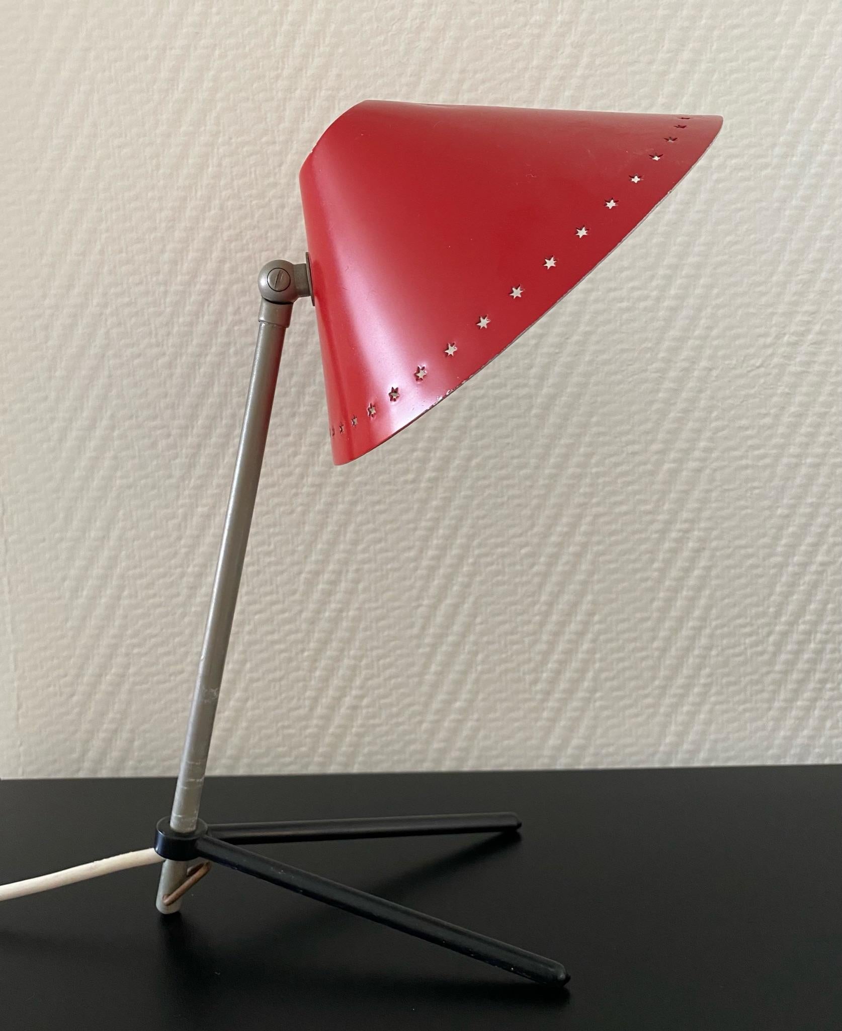 This red metal table or wall lamp, Model Pinocchio, was designed by H.J.Busquet and Manufactured by Hala Zeist, Netherlands. This small lamp can function as both table lamp and wall lamp. Adjustable in height by moving the feet. Shade can aslo be