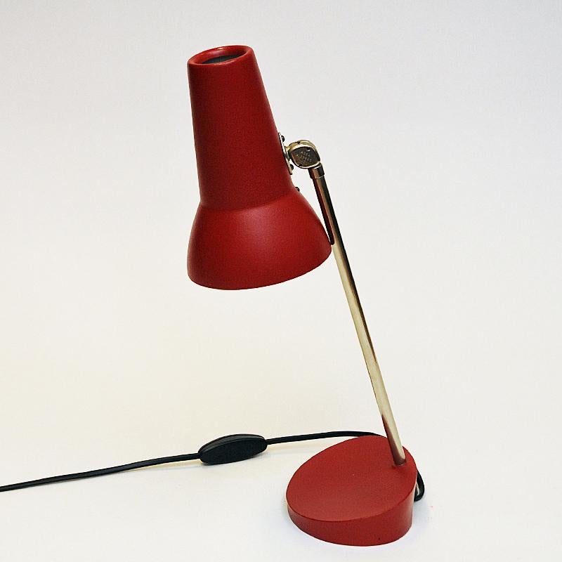 Lovely red metal table or desklamp mod E1297 produced by ASEA Belysning, Sweden in the 1950s. Brass stem with a red metal shade adjustable in all directions. Red circular base. Lightswith located on the black cord. Marked with the model number 11297