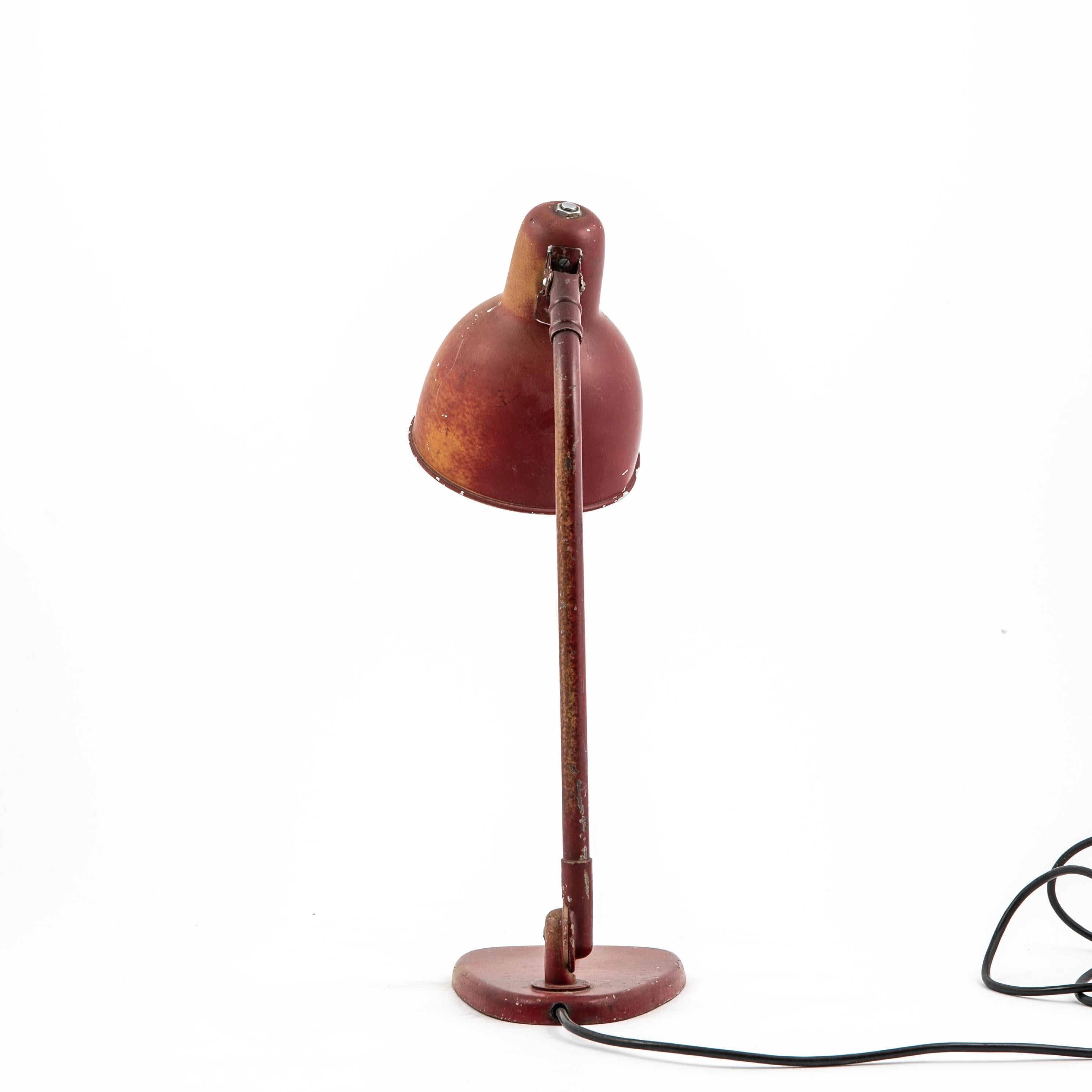 Industrial style table or desk lamp. Swedish design, 1950's.
Original red lacquer metal with charming patina. Shade is adjustable up/down. Lightswith located on base.
Great vintage condition.
Sweden c. 1950.

220V.
