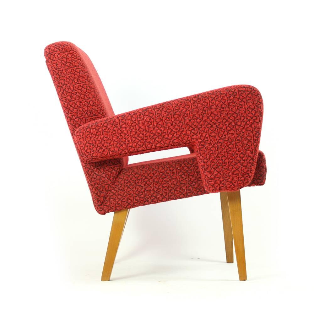 This armchair defines midcentury design and design classics by Jitona. The beautiful red armchair is combined with four wooden legs which only add to 1960s era. The chair is in original red upholstery. It is in a very good condition with only minor