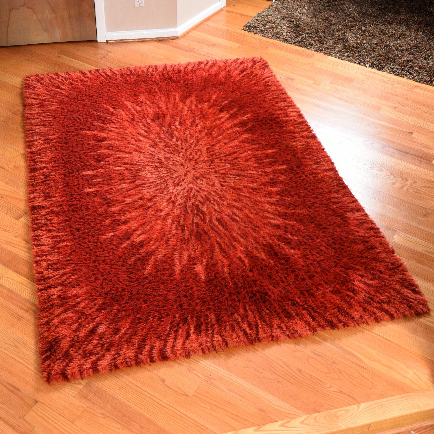 Gorgeous Mid-Century Modern red Scandinavian wool Rya rug. The roughly 5.5 x 7.75 foot rug features a starburst pattern that looks like the birth of a galaxy. Varying tones of fiery red emanate from the center of the rug. The wool carpet features a