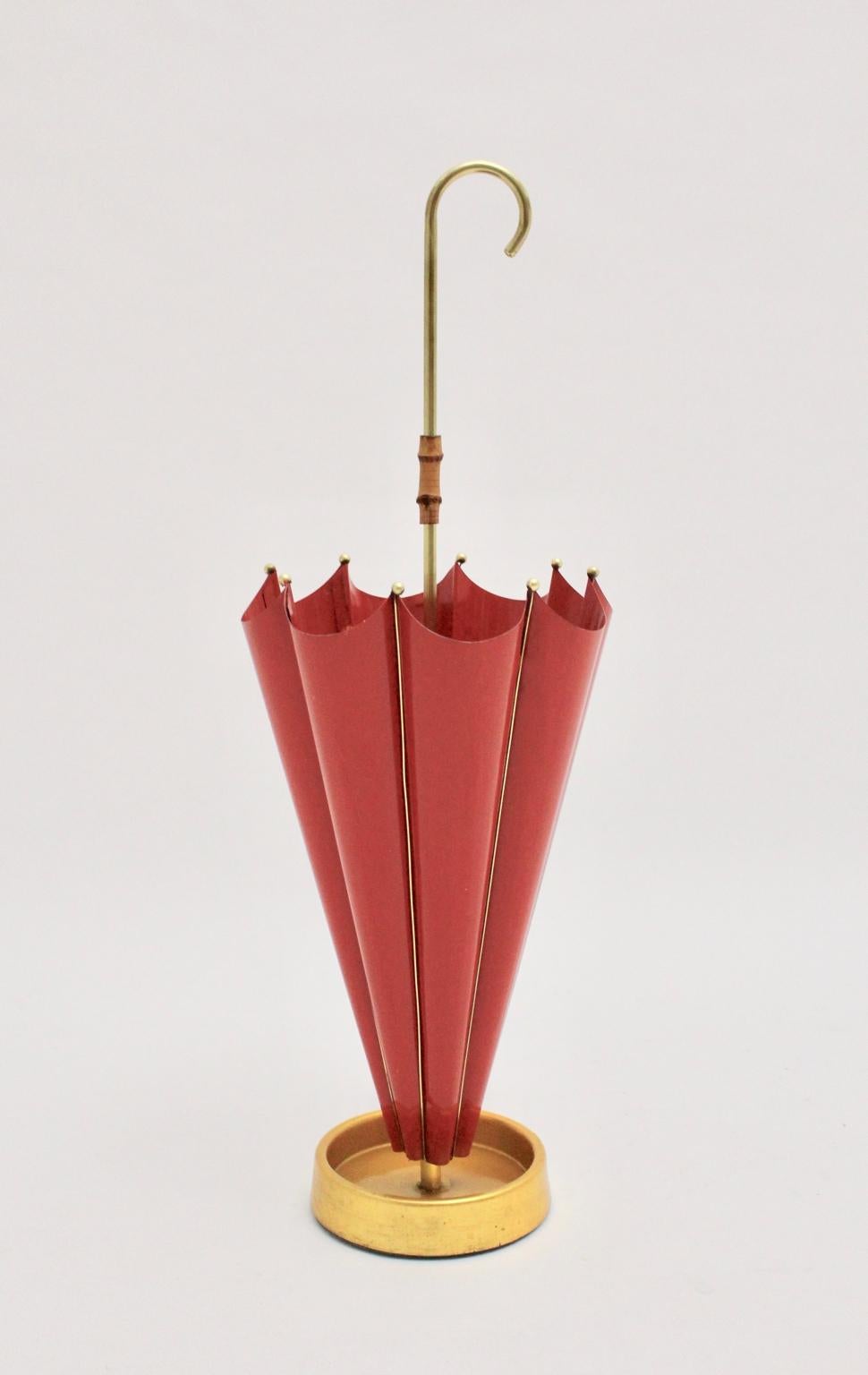 We present a very charming red umbrella stand, which shows an amazing umbrella form and was made out of red lacquered sheetmetal.
Furthermore the umbrella stand features brass details, bamboo detail, brass handle and an iron base for a firm and