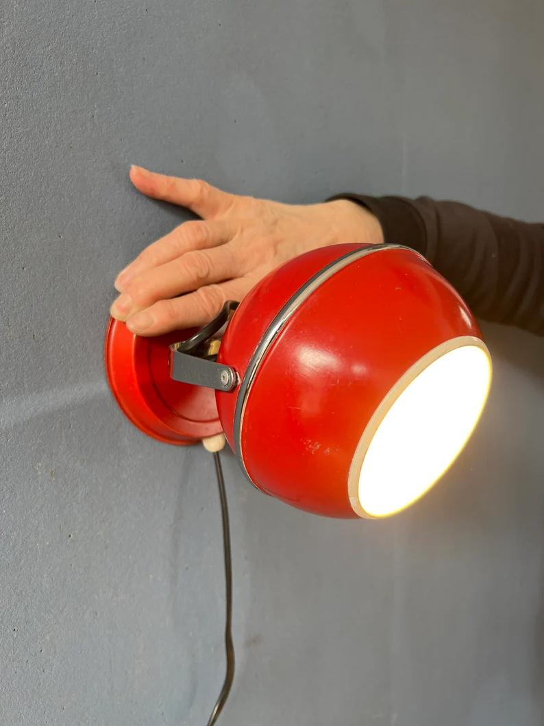 Red space age eyeball wall lamp (3 available). It might also be used as table lamp. The shade can be turned in any direction. The lamp require sone E14 lightbulb and currently has an EU-plug (works outside EU with plug-converter).

Additional