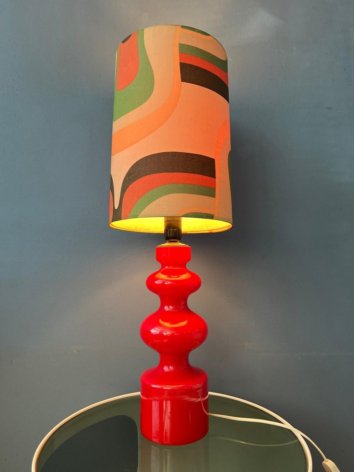 Red west germany space age table lamp with glass base and textile shade. The lamp requires one E27/26 lightbulb and currently has an EU-plug.

Additional information:
Materials: Ceramic, linen
Period: 1970s
Dimensions:ø Shade: 25 cm
Height: 62