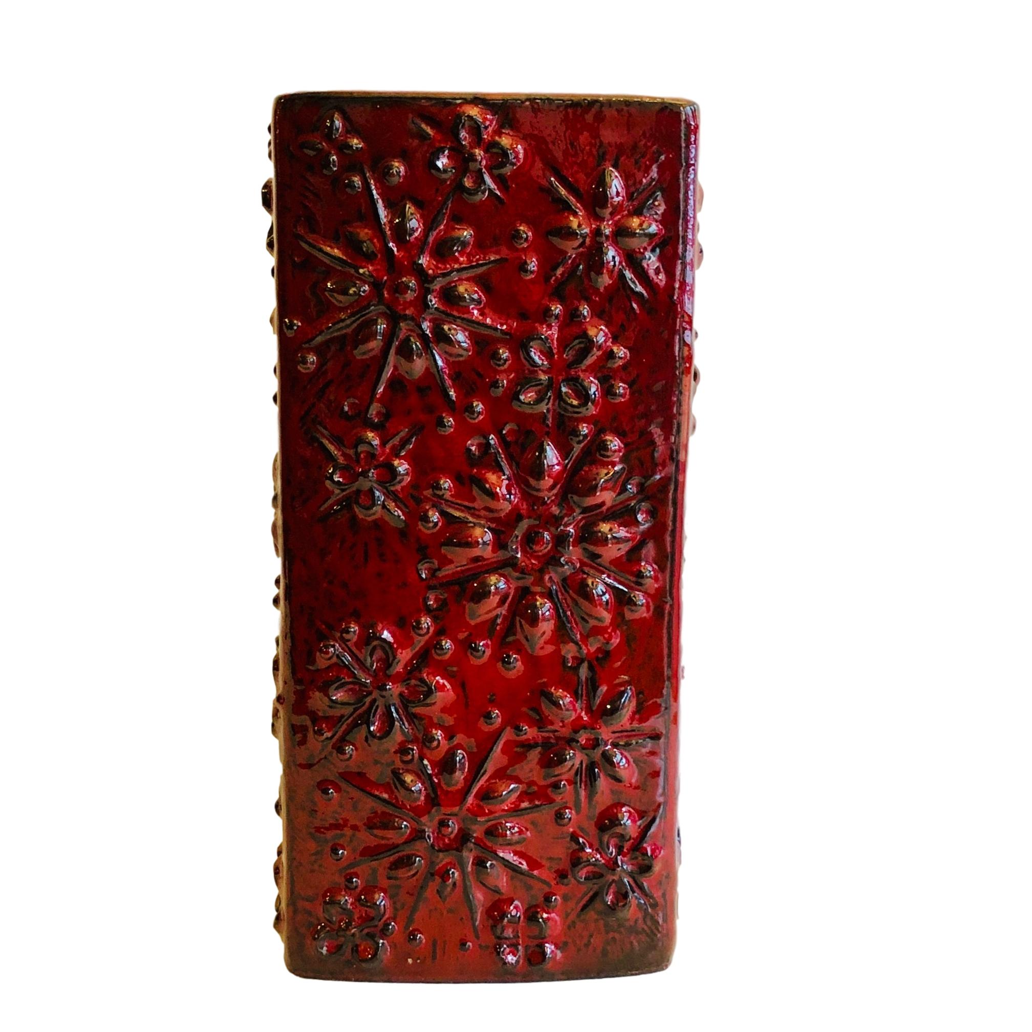 A circa 1960s German red-glazed vase with textured floral motif.

Measurements:
Height 12