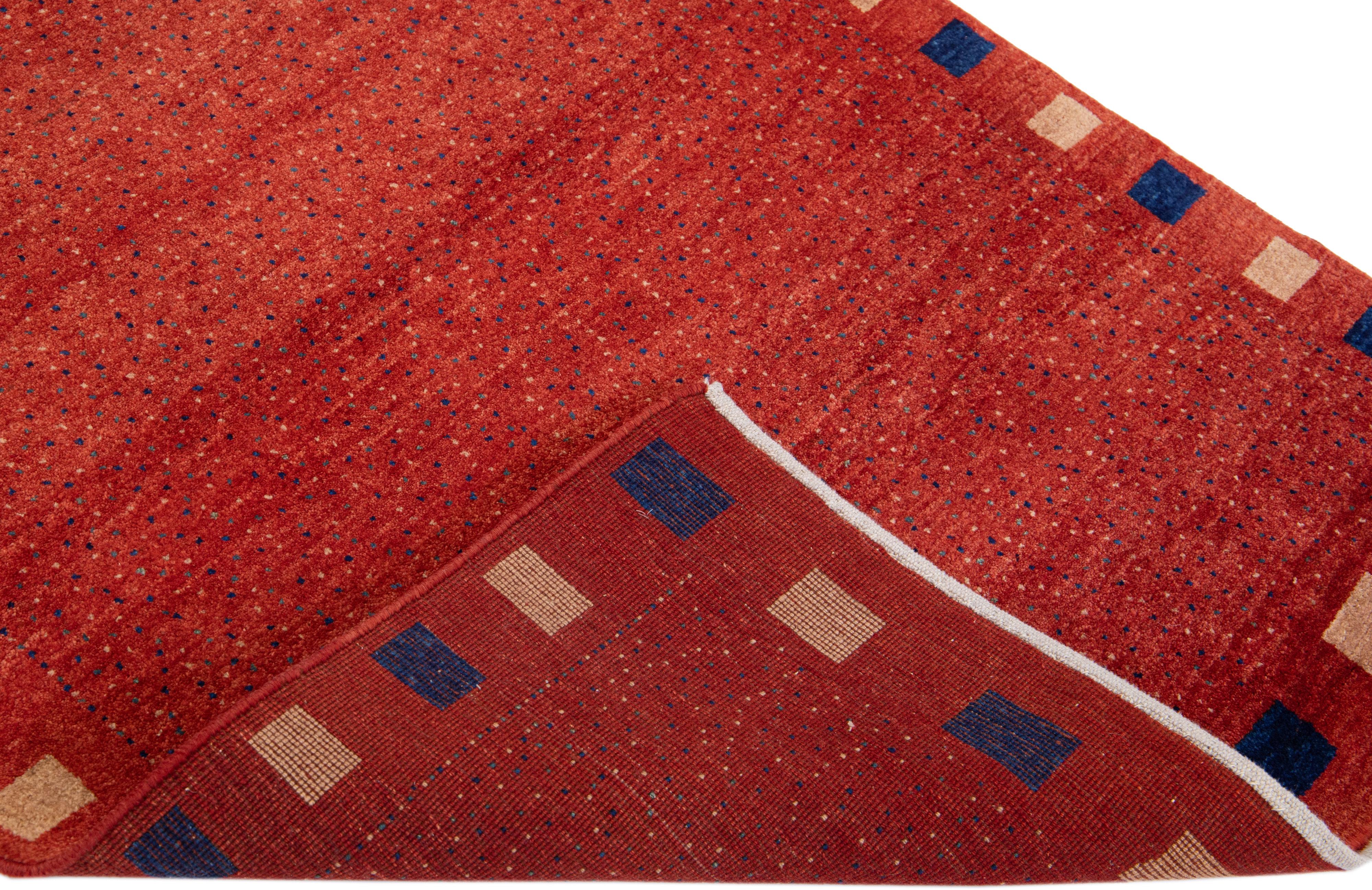 Beautiful modern Gabbeh hand-knotted wool rug with a red field. This Persian rug has beige and blue accents in a gorgeously minimalist design.

This rug measures: 3'5