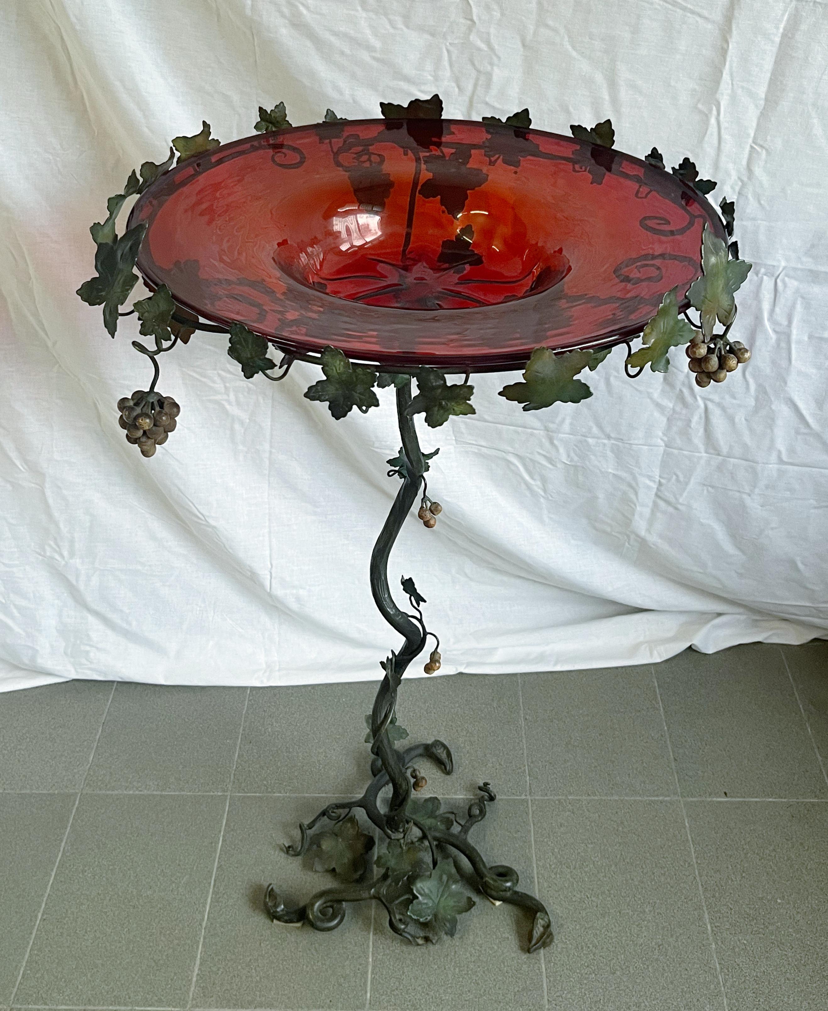 Bold and unique antique pedestal table with ruby red Murano glass plate and ornamental base in hand wrought iron with grape vines motif / Made in Italy by Umberto Belloto, circa 1930s
Diameter: 23 inches / height: 35 inches / Base diameter: 14