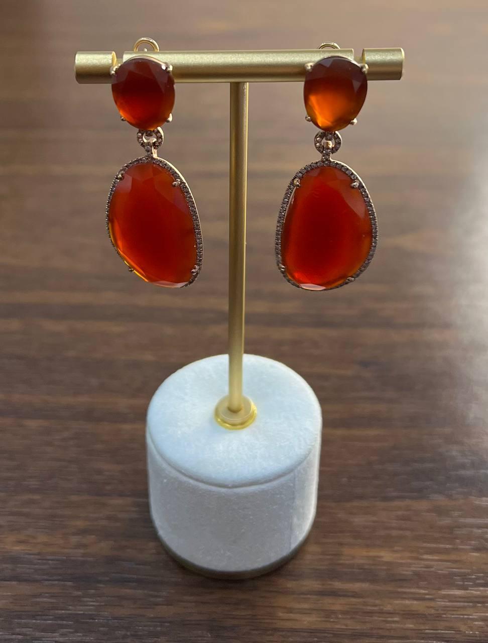 Un estudio de elegancia, calidez y encanto.
Estos llamativos pendientes presentan piedras de un rojo intenso que atrapan la luz con cada movimiento. Las cornalinas rojas anaranjadas, lisas y de forma ovalada, están engastadas en un delicado marco de