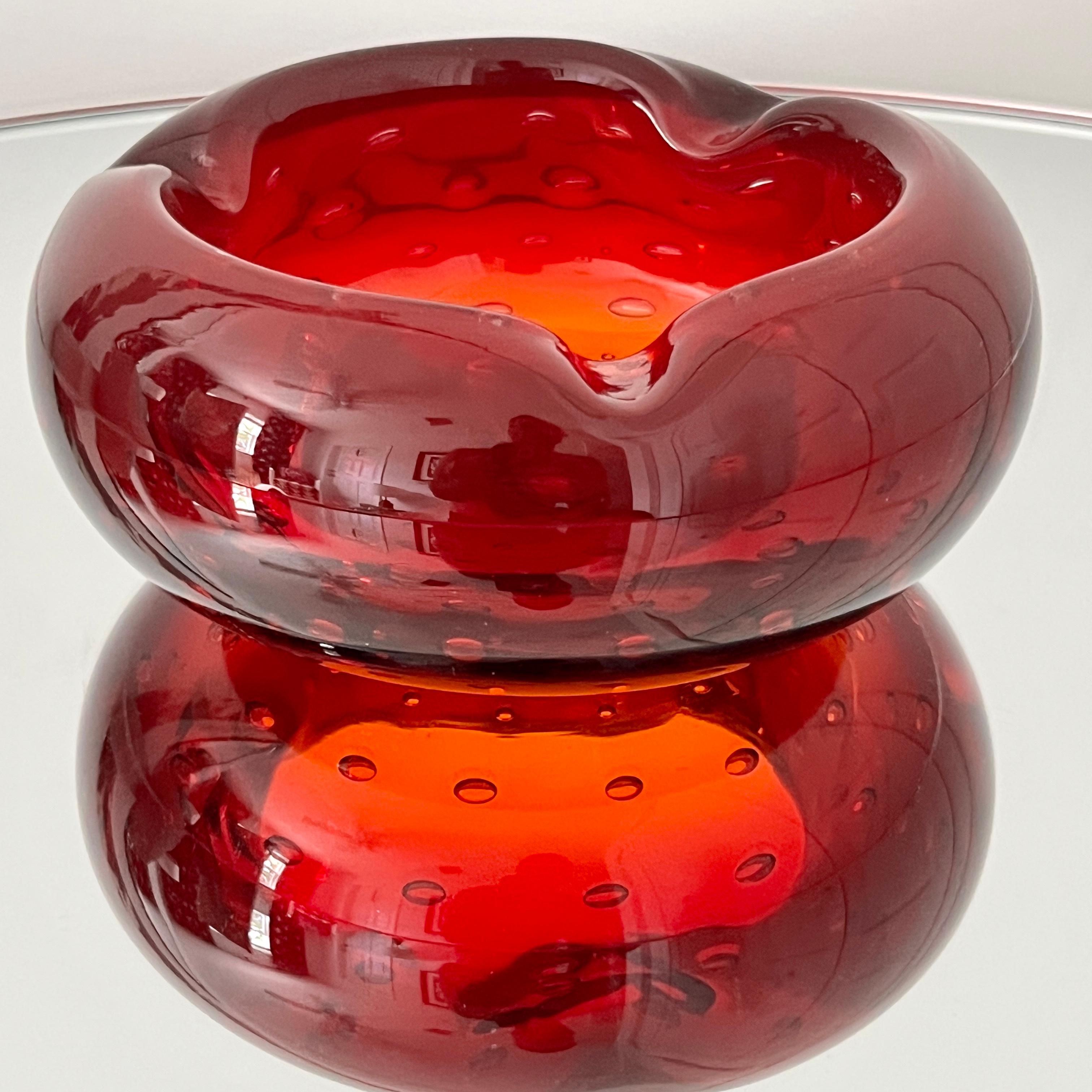 Mid-Century Modern Venetian glass ashtray in hues of deep red and orange. Handblown chunky glass with beautiful rounded form featuring controlled bubble accents and curved notches along the rim. Can be also be used as a decorative object, vide-poche