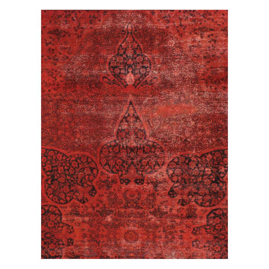 This 21st century creation consists of an antique Persian Lavar Kerman from the early 20th century (circa 1910) that has been overdyed red and intentionally distressed to offer a shabby-chic appeal. A modern touch to a traditionally timeless