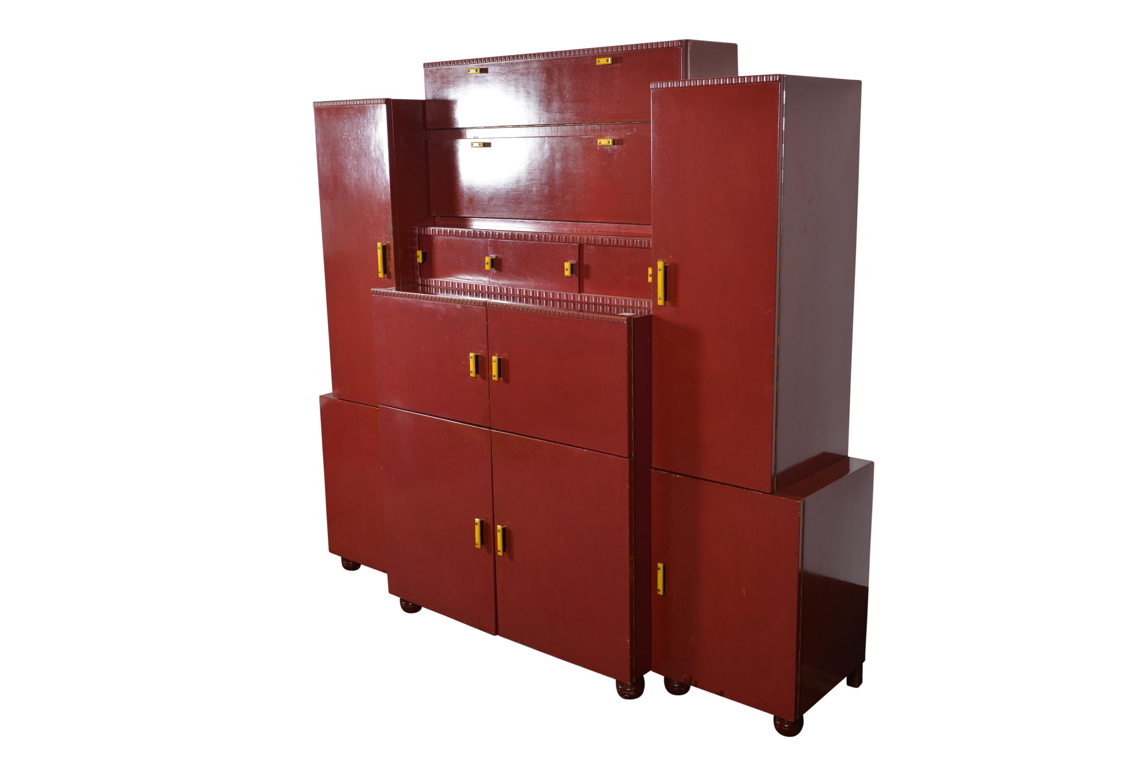 Art Deco cubist cabinet in striking red original color. The influence of Cubism gives this Art Deco cabinet a more fragmented, geometric character. Art Deco flowingly varied in its influences, taking inspiration from Egyptian art, Aztec Art, ship,