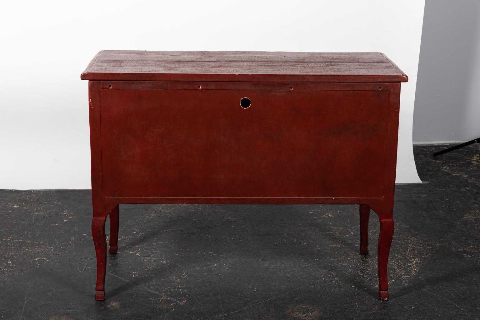 Red painted Continental style two-drawer chest with metal pulls and landscape scenes on the drawer fronts and sides. Please note of wear consistent with age including paint loss and chips.