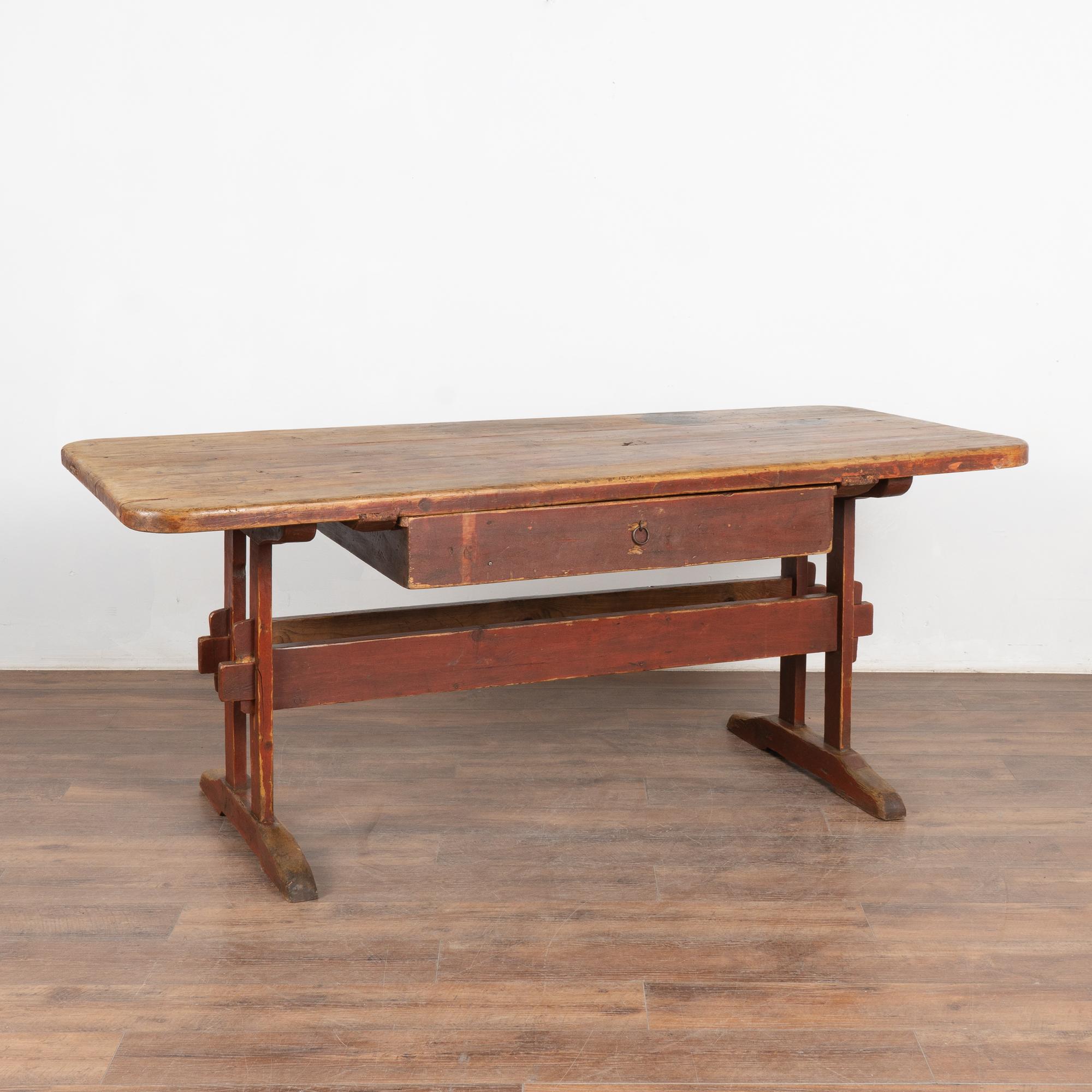 La beauté de cette table de ferme en pin provient de la chaleur du pin vieilli et de la base à tréteaux originale peinte en rouge brique.
Elle a peut-être servi à l'origine de table de travail dans la cuisine d'un manoir de campagne. Notez les