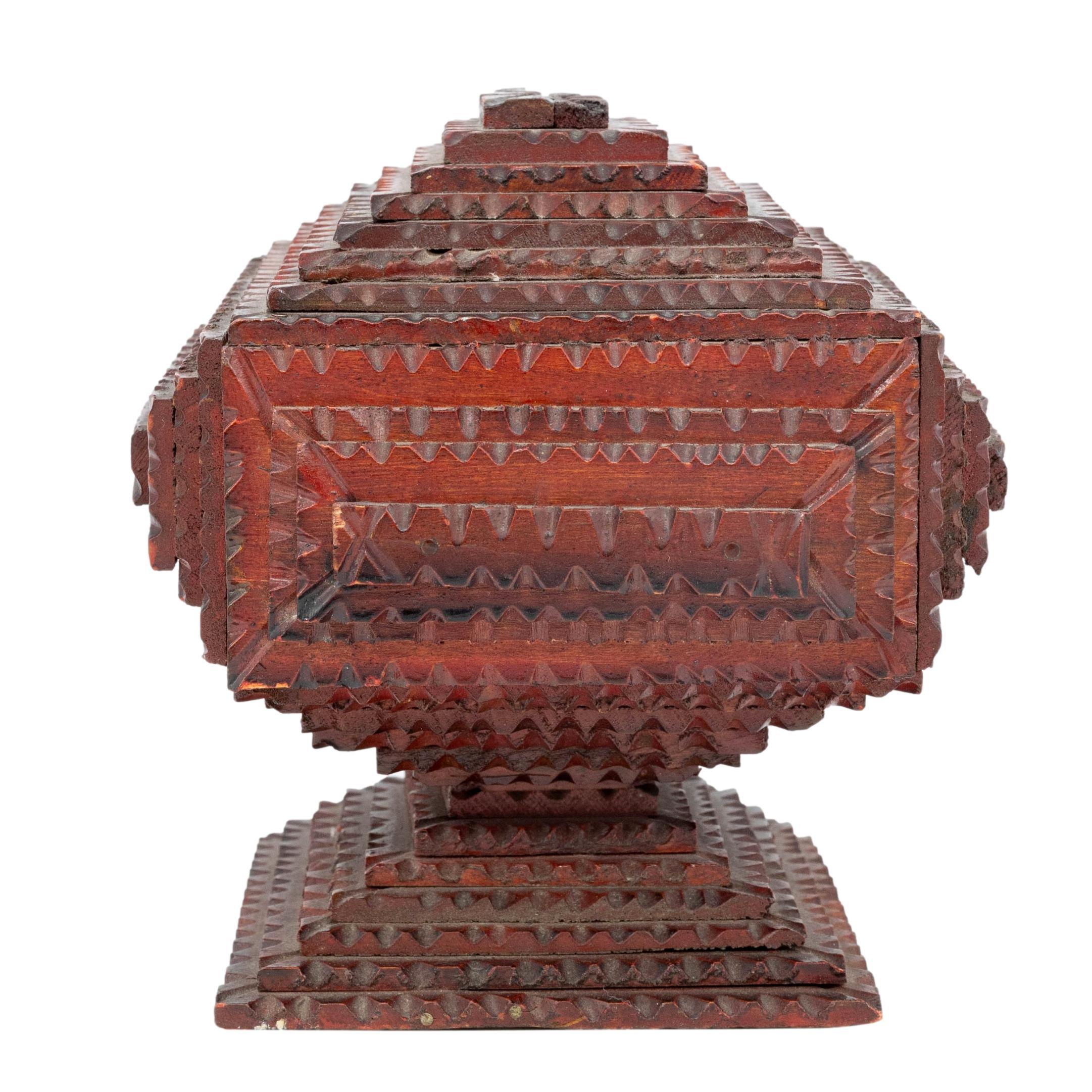 Tramp Art pedestal box made from wooden cigar boxes, of pyramid form, with jigsaw tooth notching and carved pyramids, retaining original red painted surface, with cigar drawer, American, ca. 1920.