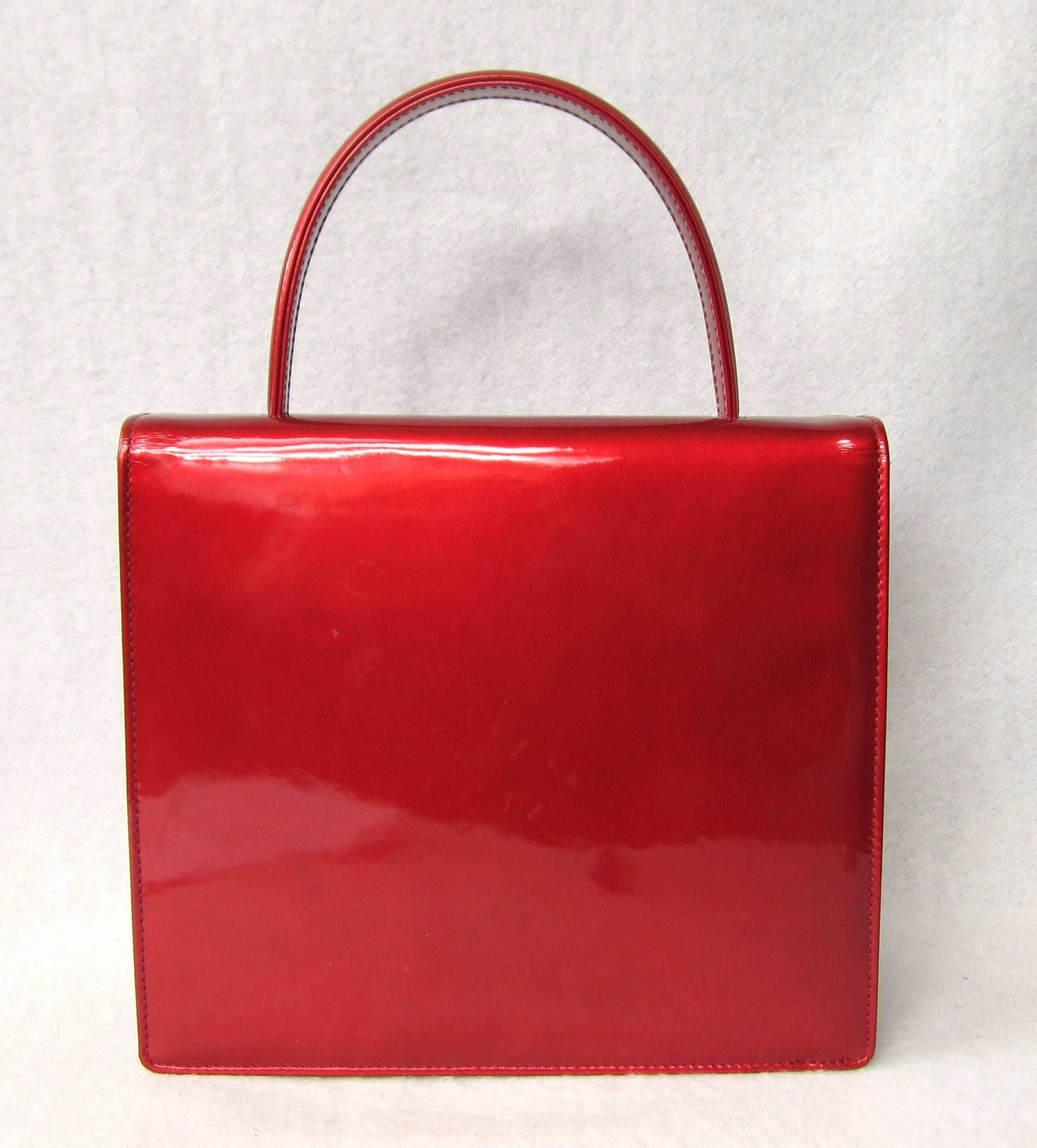 Another Escada hand bag in a stunning red purchased in the late 1980s early 1990s stored away, never used. Has Red suede interior. Measuring 8.75 wide  x 7.75 H x 2.75 deep. One main compartment and a small compartment inside. It has a tiny mark on