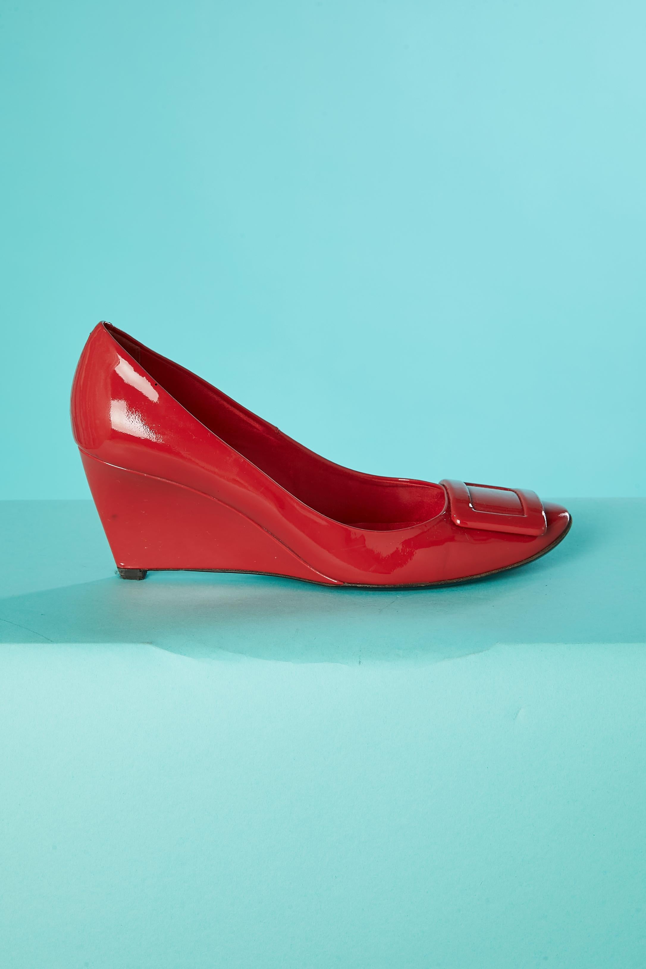 Red patent leather wedge pump with red buckle. 
Heels height : 6,5 cm
Shoes SIZE : 38,5 (Eu) 7 (Us) 