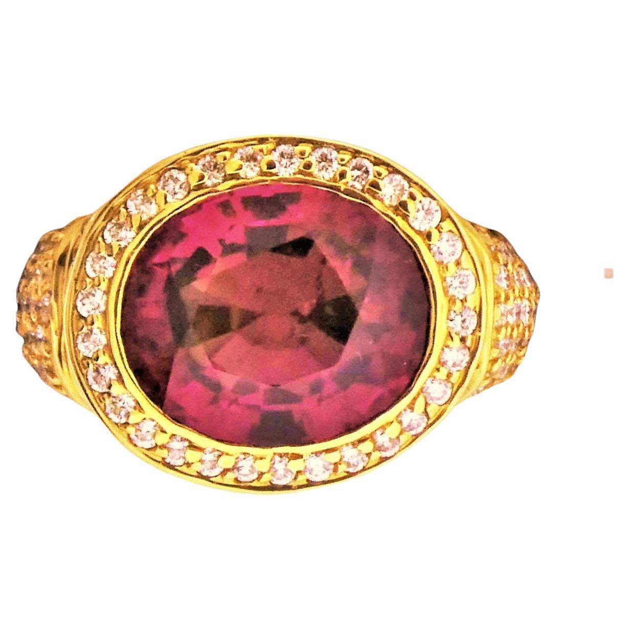 The Redish Pink Tourmaline (5.82 cts) created from Afghanistan rough material is set in an 18K Yellow Gold mounting that weighs 12.5 grams.  The under bezel and shoulders of the ring contain 147 diamonds that weigh 1.55 cts which are graded as G/H
