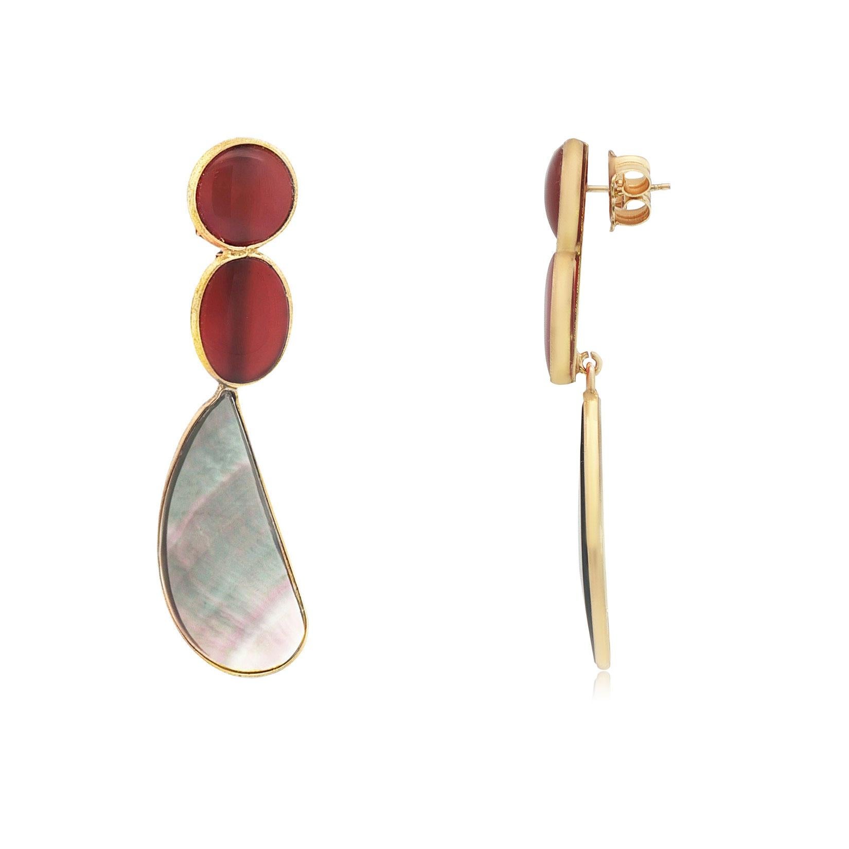 Fai una dichiarazione audace ed elegante con questi orecchini, caratterizzati da un quarzo rosso intenso abbinato a lacrime di labradorite iridescenti. Incastonato in argento con una ricca finitura dorata, il sorprendente contrasto tra il vibrante