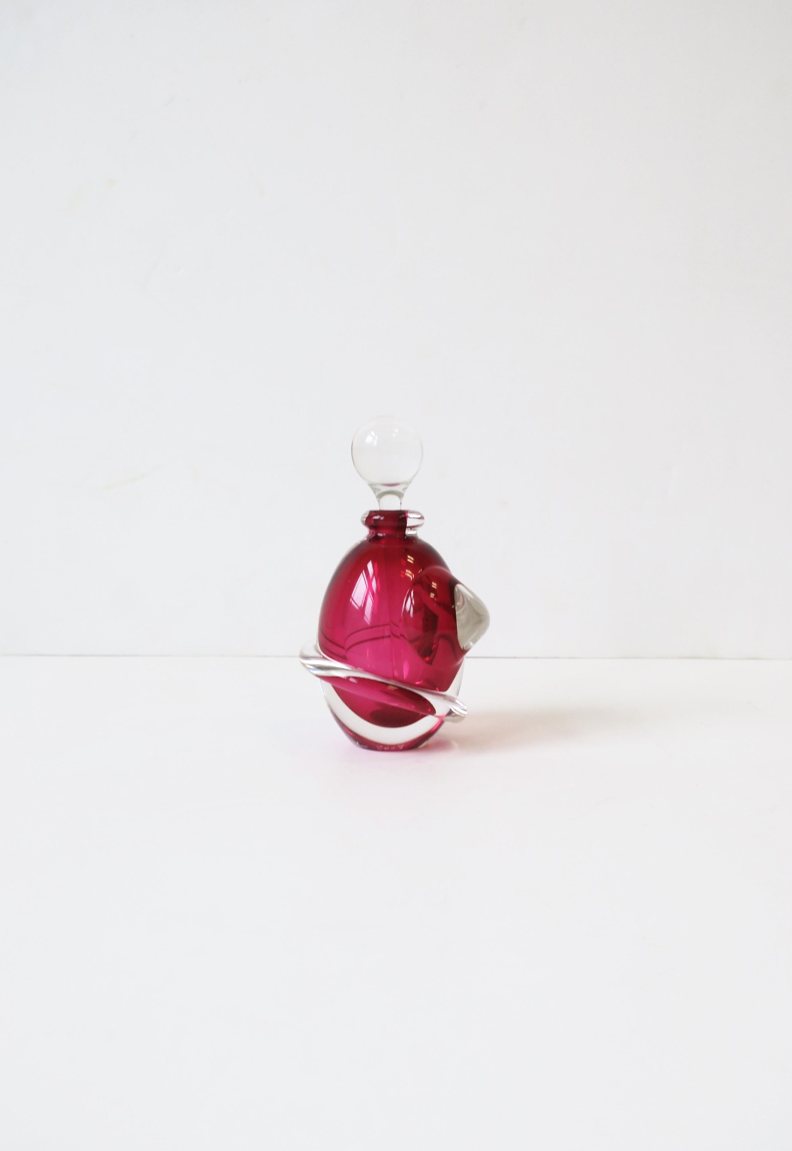 A very beautiful red raspberry art glass perfume vanity bottle signed and dated on bottom, circa early-21st century, 2008. Bottle is red raspberry and clear art glass, oval in shape with clear twisting design around, finished with a clear art glass